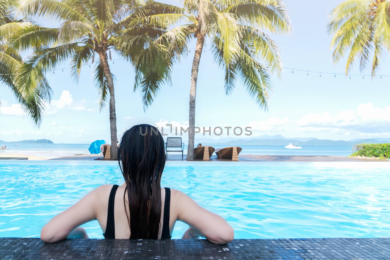 Rear view Asia woman enjoy in the swimming pool