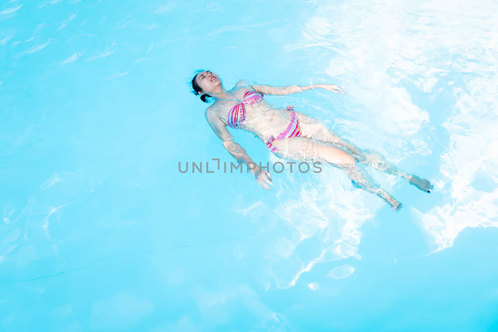 Beautiful Asia woman enjoy swimming in the pool