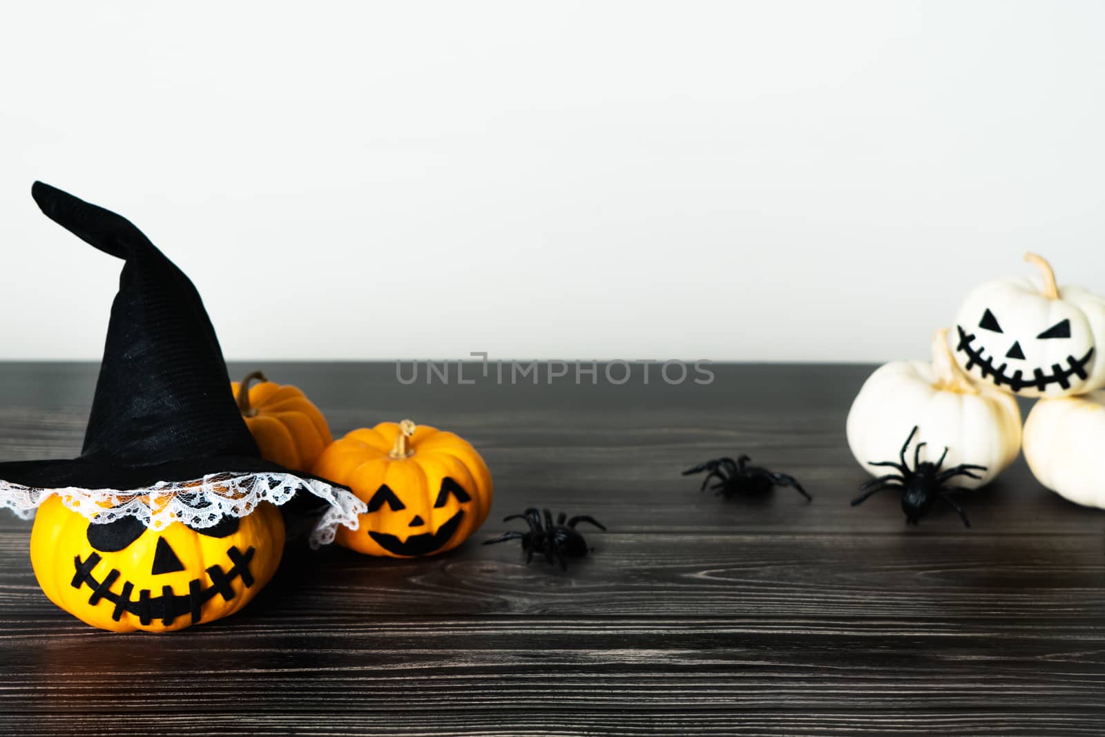 Happy Halloween, horror pumpkin and scary spider on wooden table