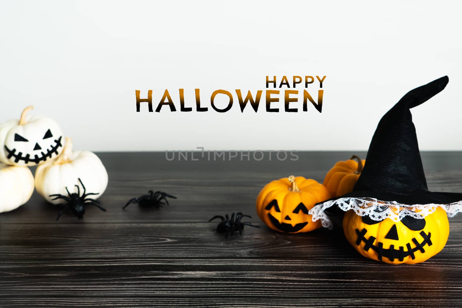Happy Halloween, horror pumpkin and scary spider on wooden table