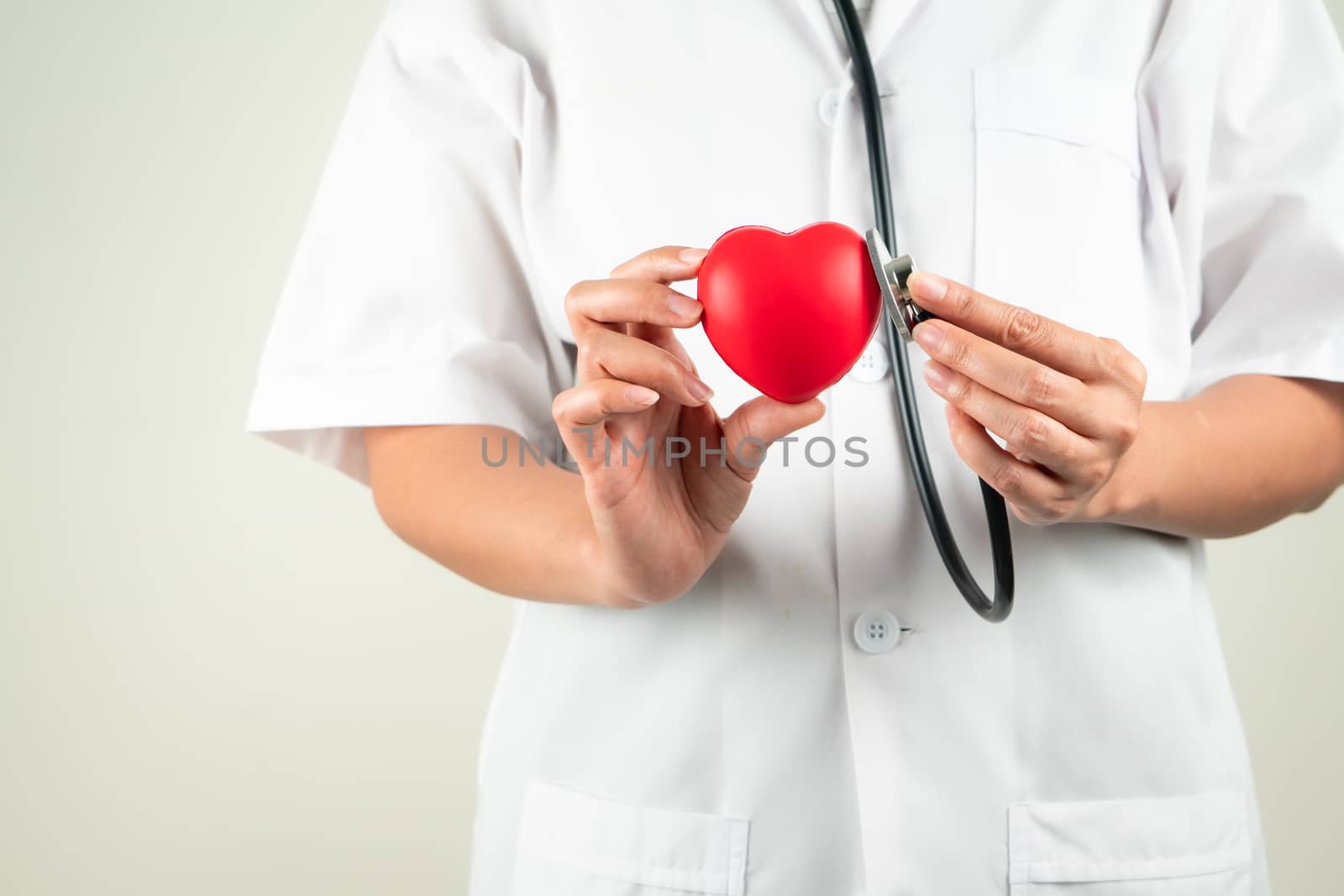 World heart day concept of woman doctor hand holding red heart and stethoscope