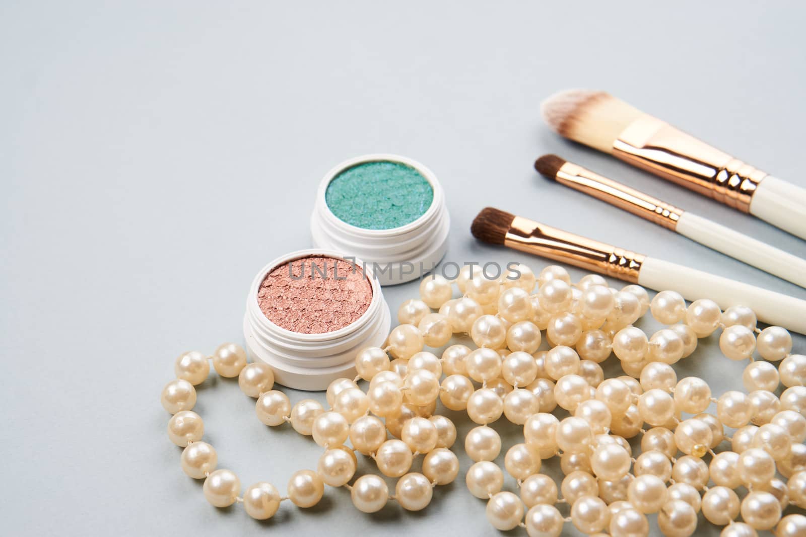 eyeshadow accessories beads makeup brushes collection professional cosmetics on gray background by SHOTPRIME