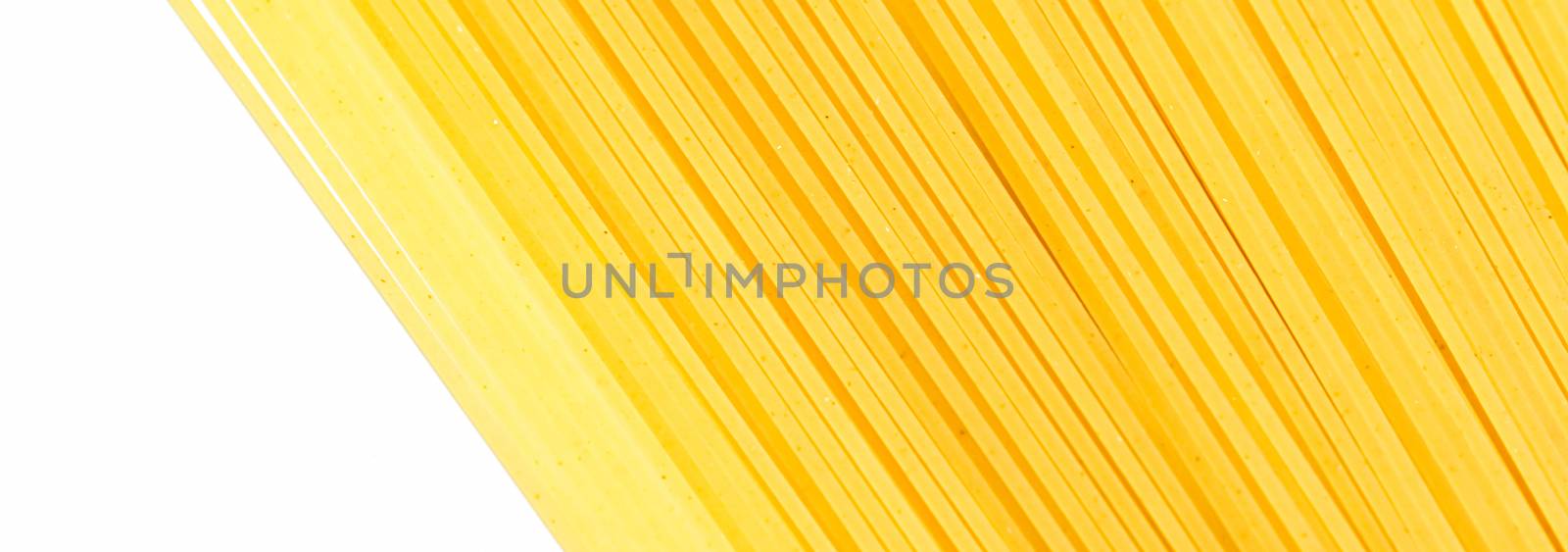 Uncooked whole grain spaghetti closeup, italian pasta as organic food ingredient, macro product and cook book recipe by Anneleven