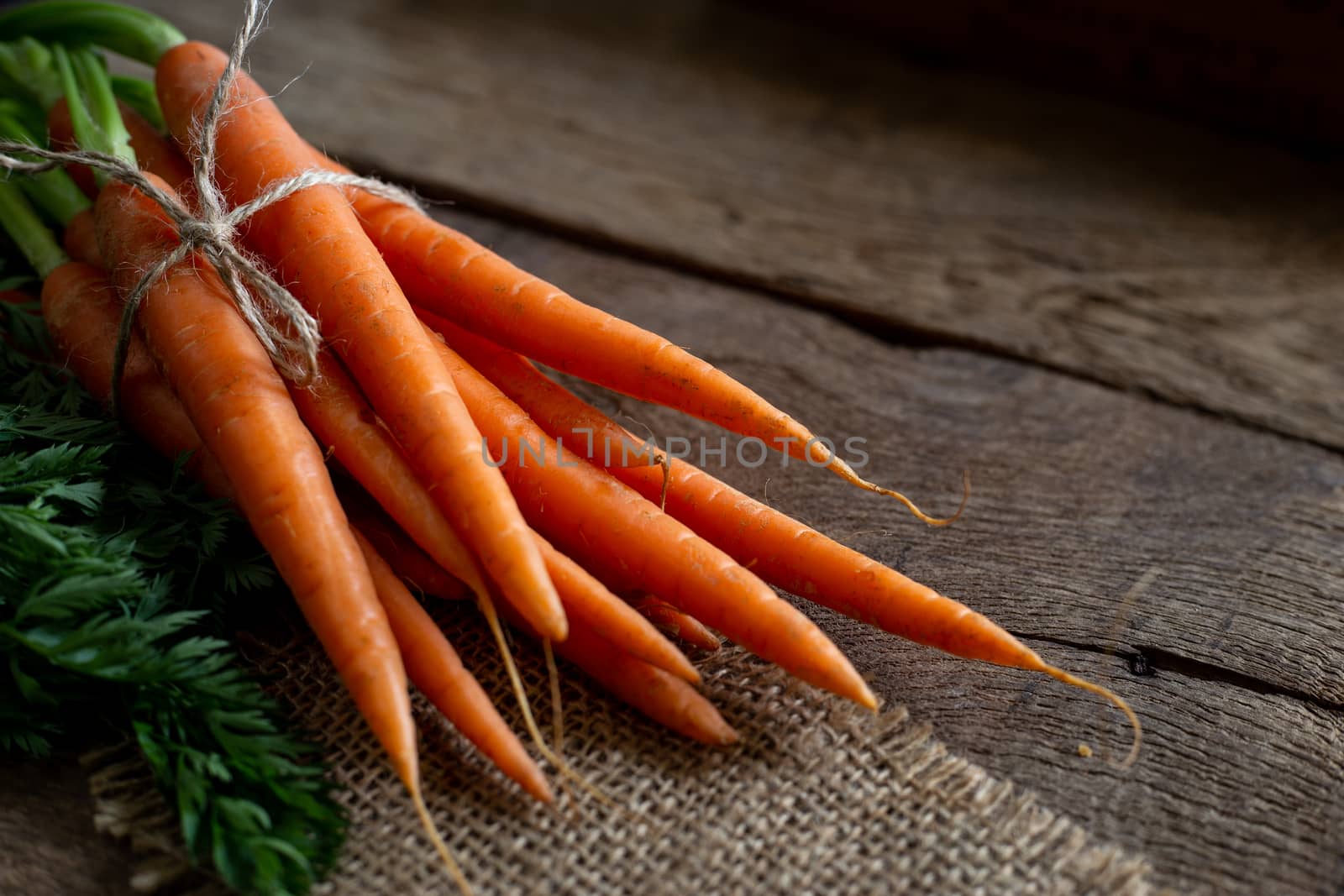 Fresh organic carrots on antique wooden table, soft focus