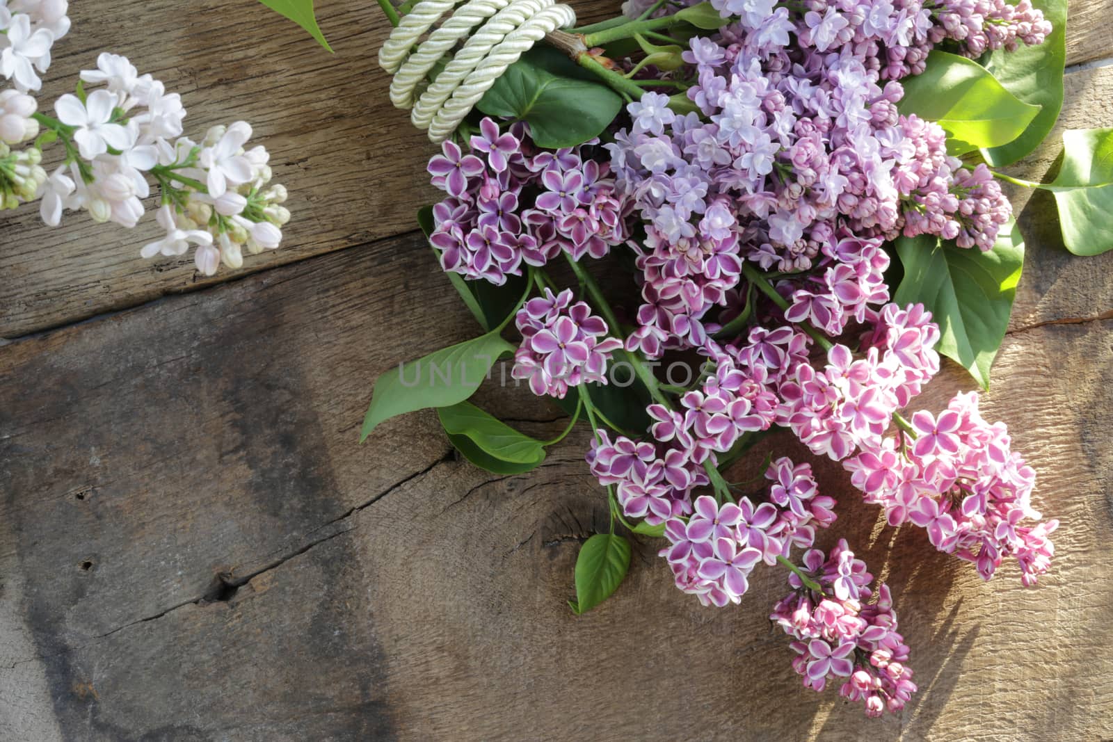 beautiful purple spring flowers with gift tag. Lilac flowers on old antique brown wood rustic background. Top view, flat lay. by NelliPolk