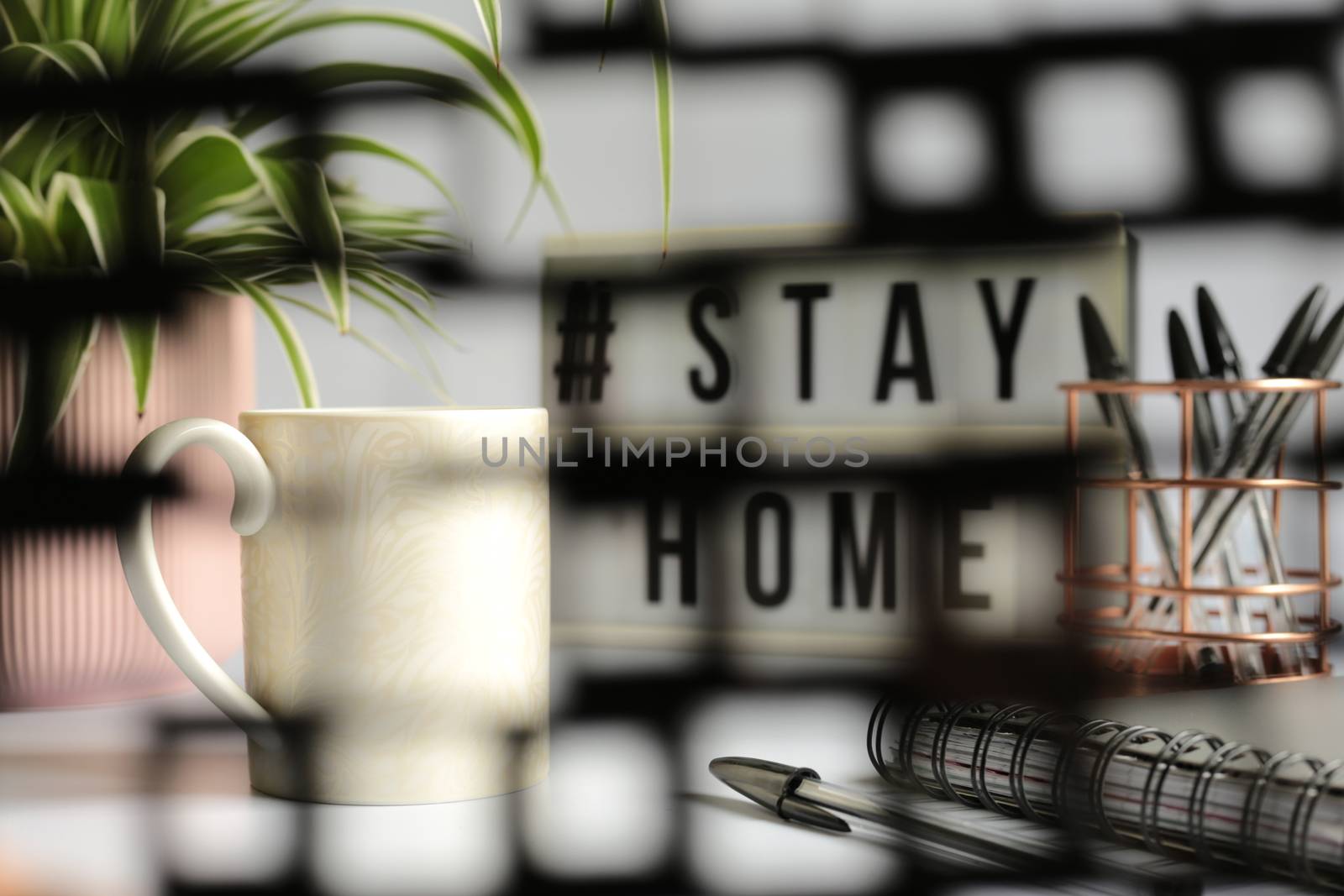 Home office desc concept during self quarantine as preventive measure against virus. Stay safe concept. Cup of coffee, clock, stationary, home plant on white background viie via soft focus net