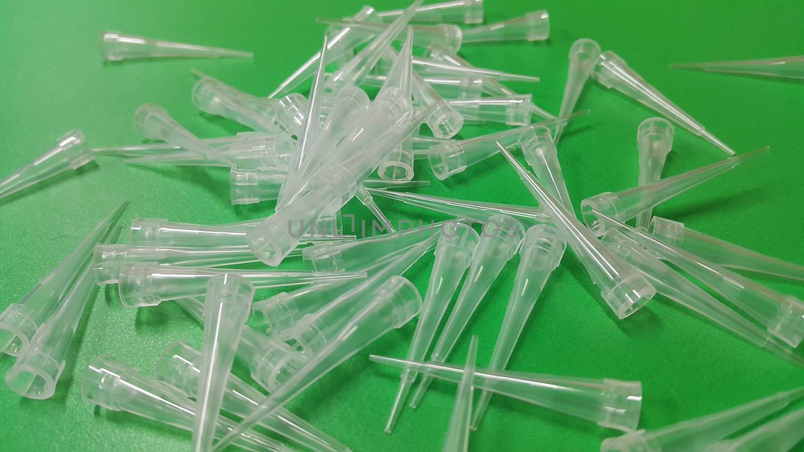 Close up view of micro litre tips on green floor sheet with empty holes. Reseach lab. tool for accurate measurement.