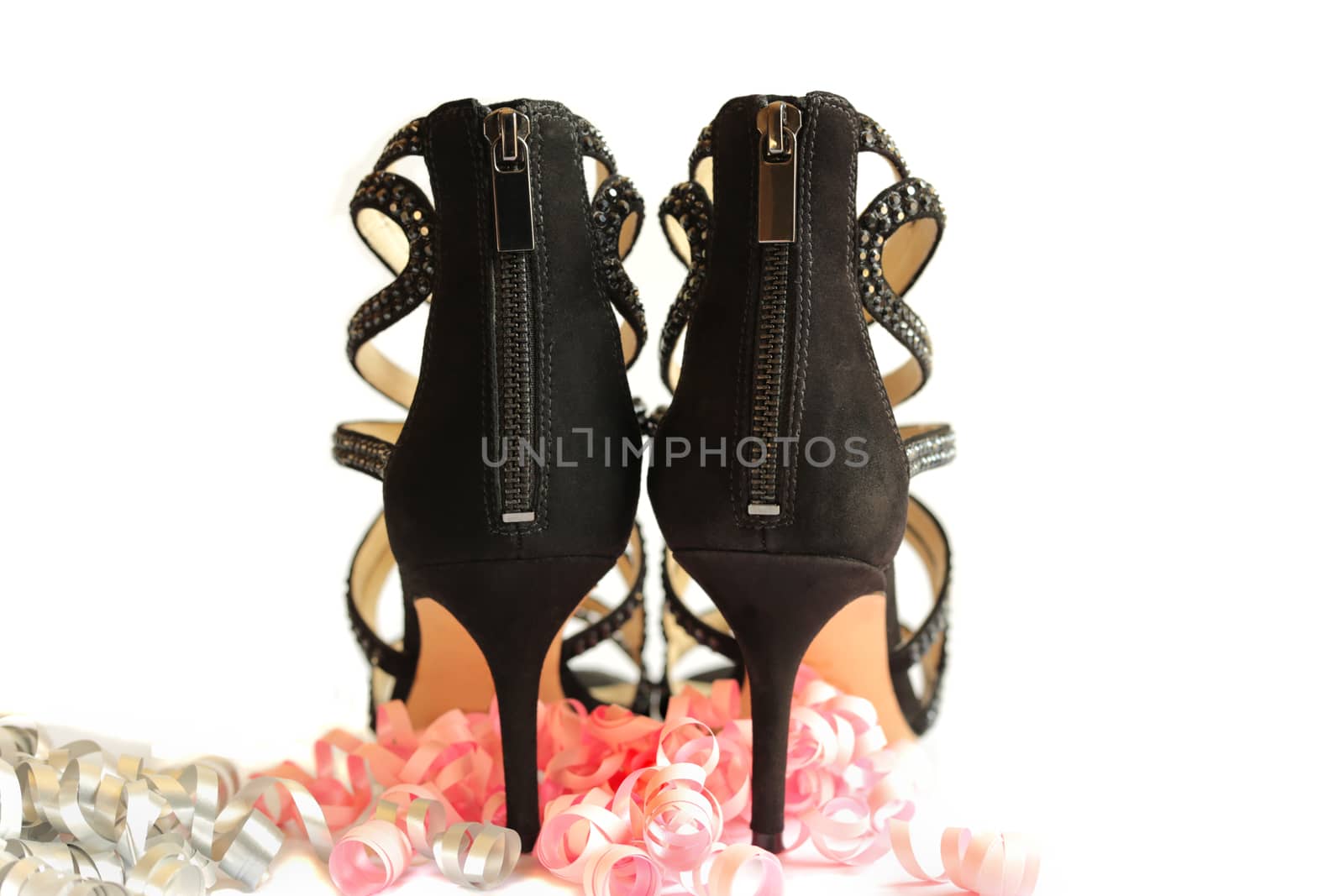 pair of black high heels shoes with pink party streamers. Woman Shoes Isolated on the White Background. High Heel Shoes. Party concept