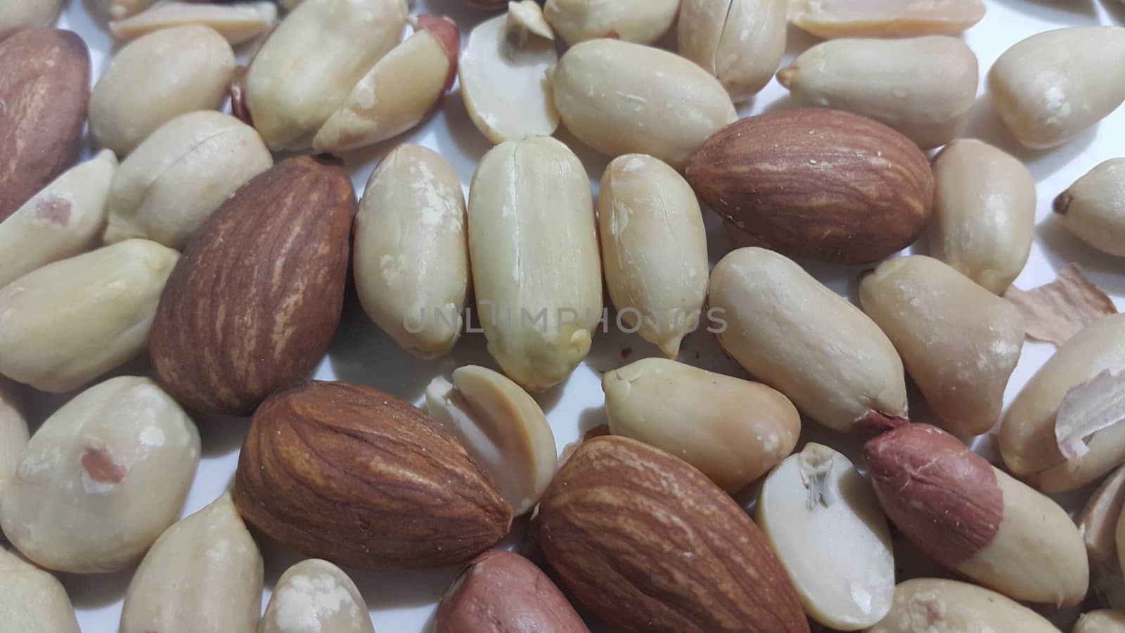 Closeup view of mixed dried and roasted  peanuts and almonds. A fruit for background text