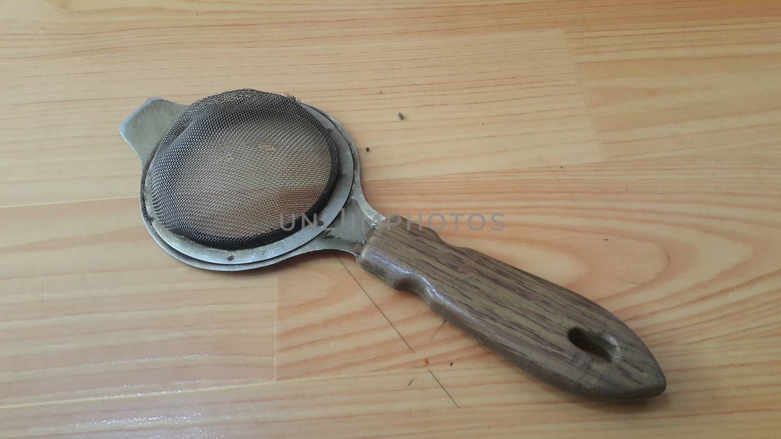Close up view of chinois with metal gaze place on a wooden floor. This chinois is use for tea infusion in traditional tea services.