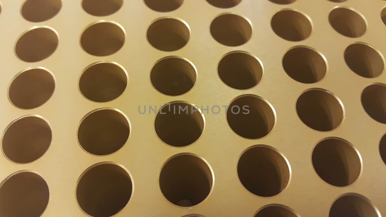 Close up view of holes in golden micro pipette box in research laboratory by Photochowk