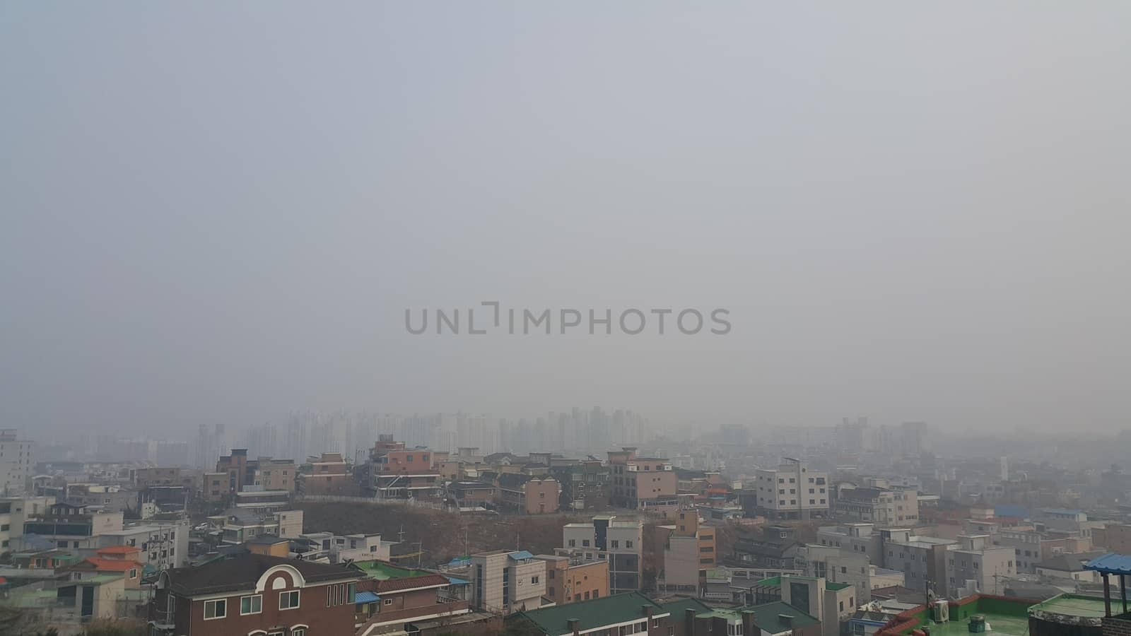 Cityscape aerial view of developed country with  dusty, smogy or amoky background in the sky and skyscraper buildings.