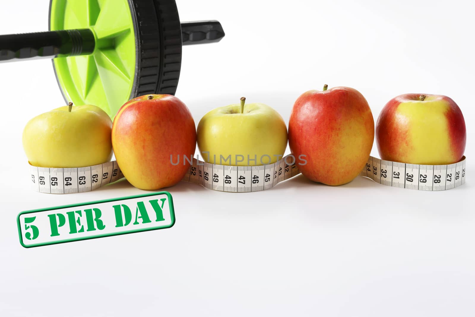 Healthy life concept. Multicolored apples with measure tap and ab wheel on white background