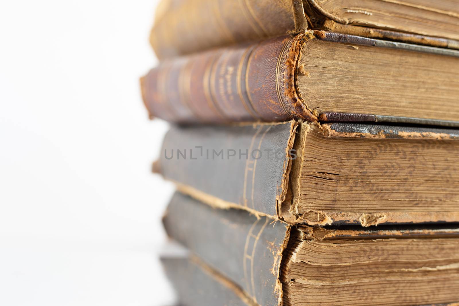 Pile of old antique brown leather cover books on white background. Concept of learning, studying at home during coronavirus. Open university, college course, online distance learning,