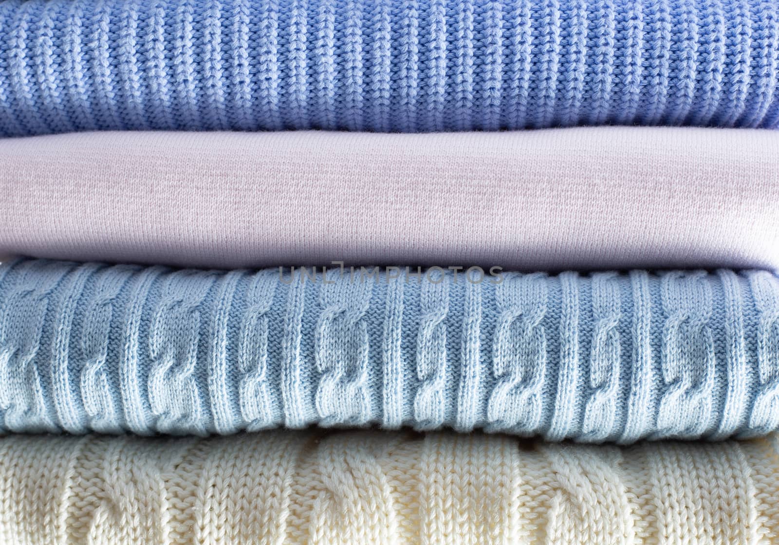 Pile of light pastel woolen clothes by NelliPolk