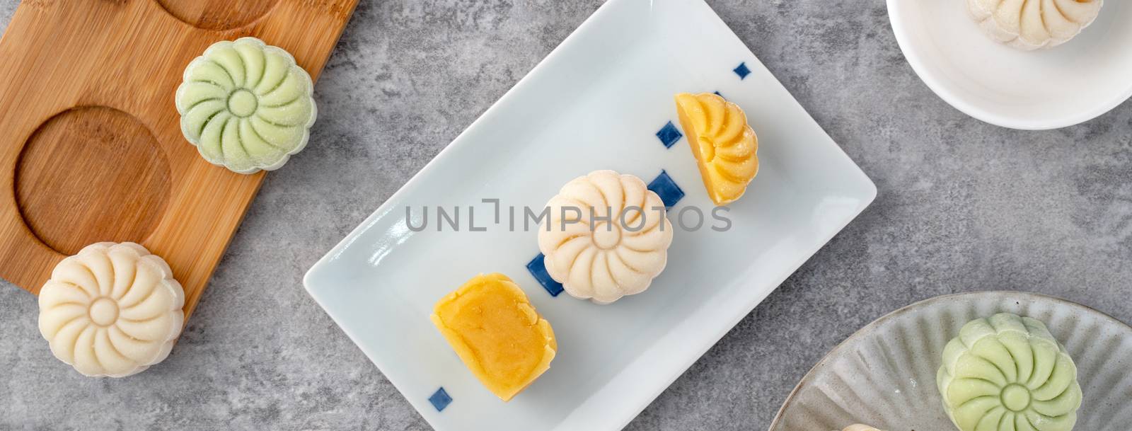 Colorful snow skin moon cake, sweet snowy mooncake, traditional savory dessert for Mid-Autumn Festival on gray cement background, top view