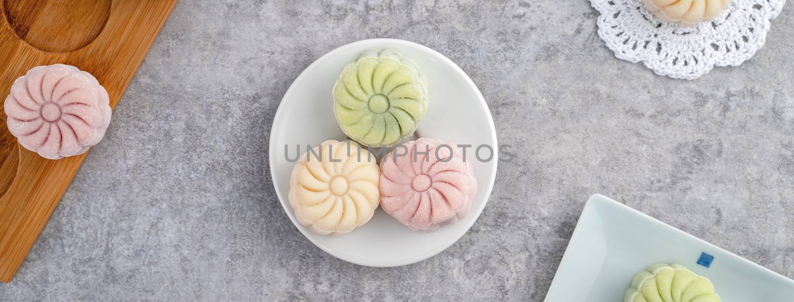 Colorful snow skin moon cake, sweet snowy mooncake, traditional savory dessert for Mid-Autumn Festival on gray cement background, top view