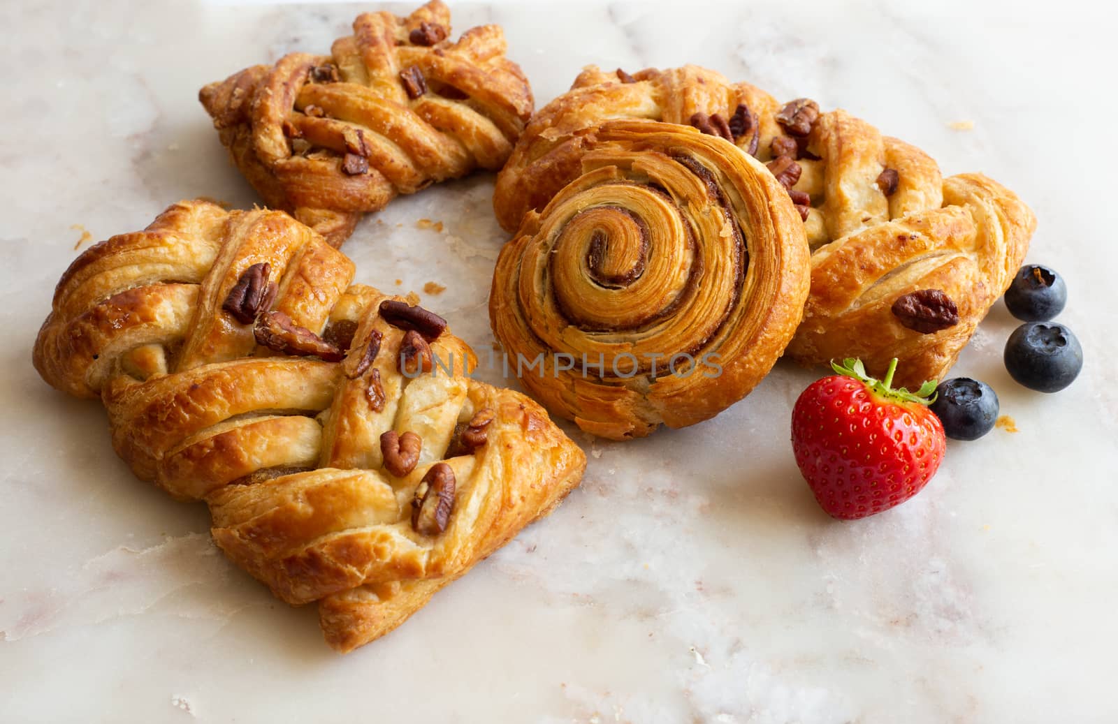 selection of French, Danish pastries with summer fruits on white marble background. Breakfast, morning treat, continental cafe