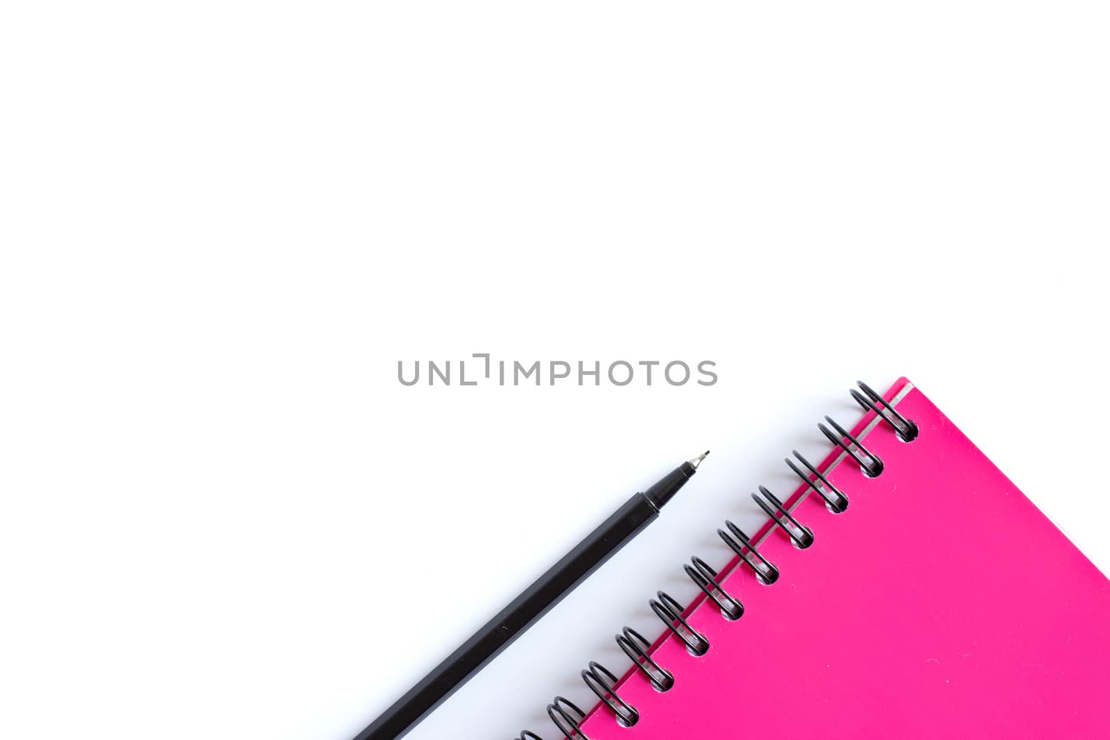 Bright pink spiral planner and balck pen. Stationery flat lay. Back to school, home office, things to remember concept. White background