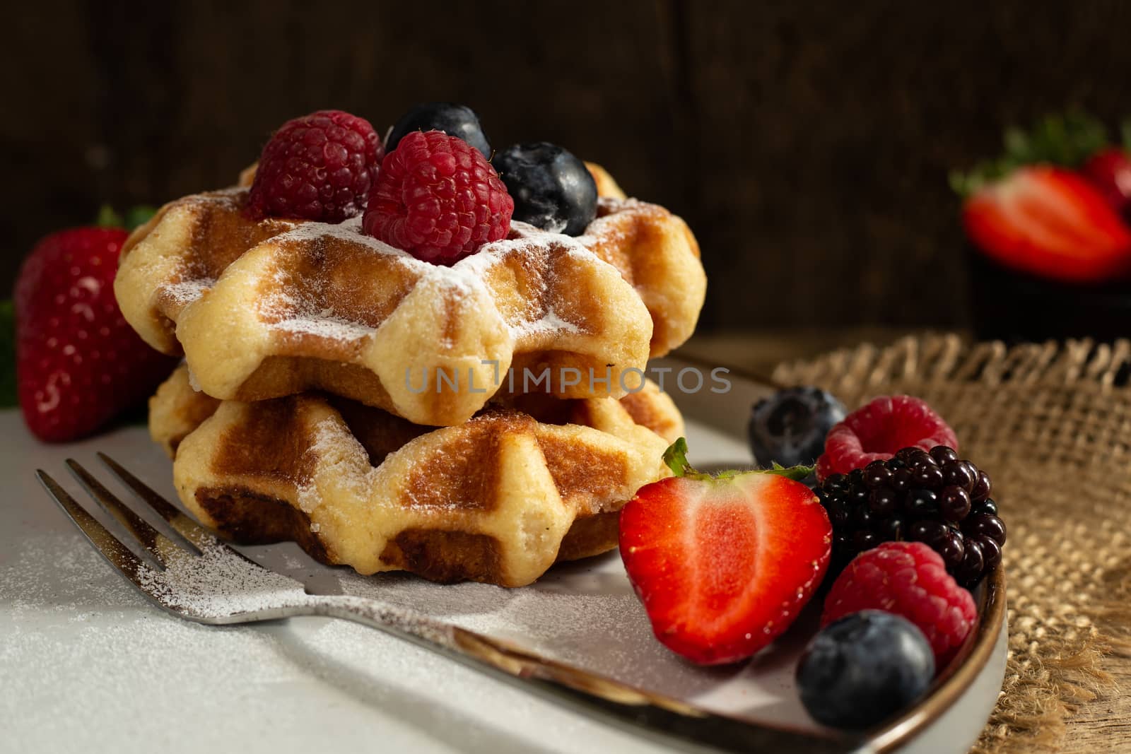 Belgian waffles with summer fruits on plate on dark wooden background. by NelliPolk