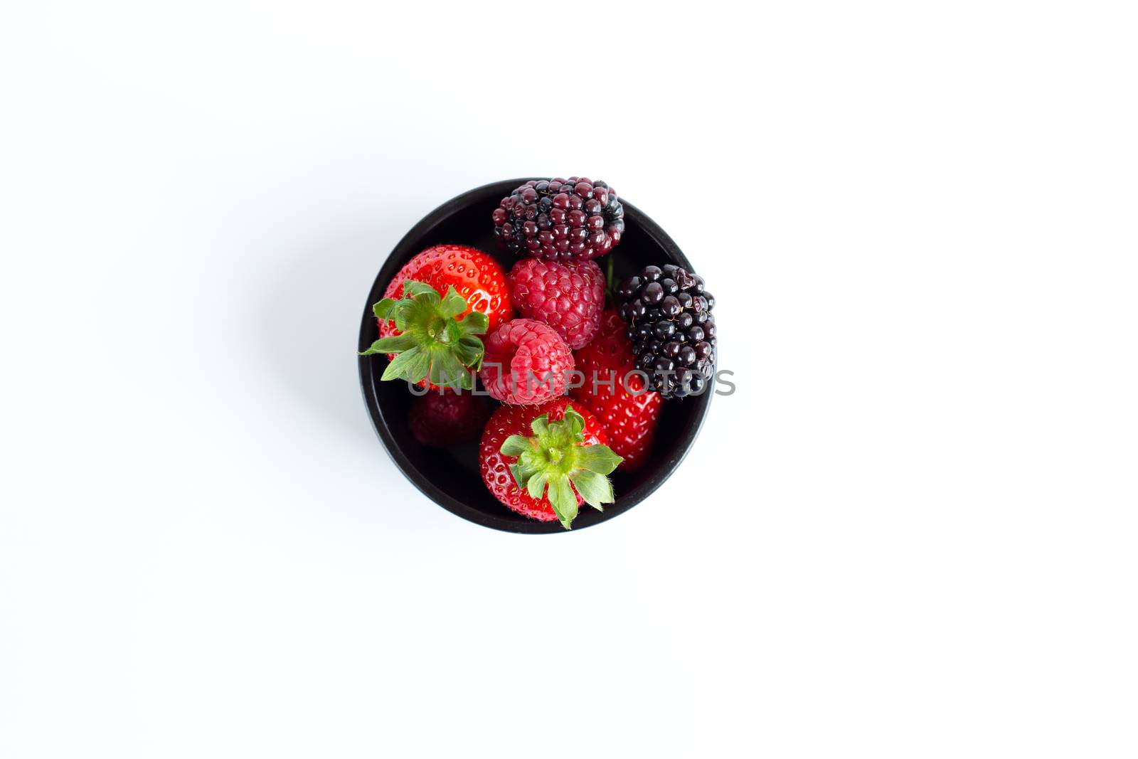 wild berries in bowl on white background by NelliPolk