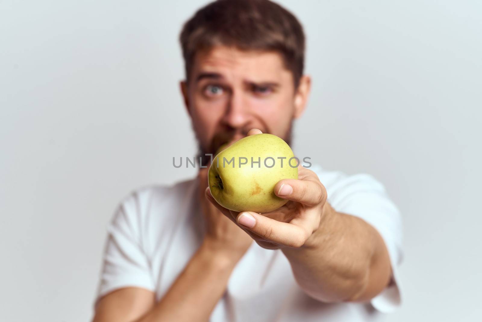 Energetic man with apples health vitamins diet and lifestyle white t-shirt cropped view by SHOTPRIME