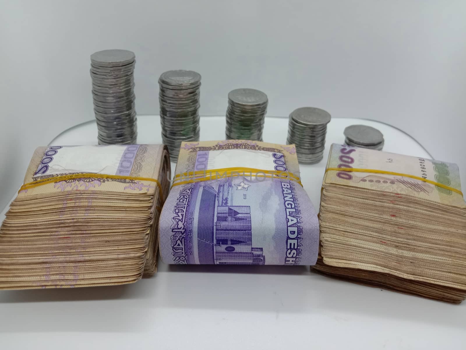 bangladeshi bank note and coin on white background