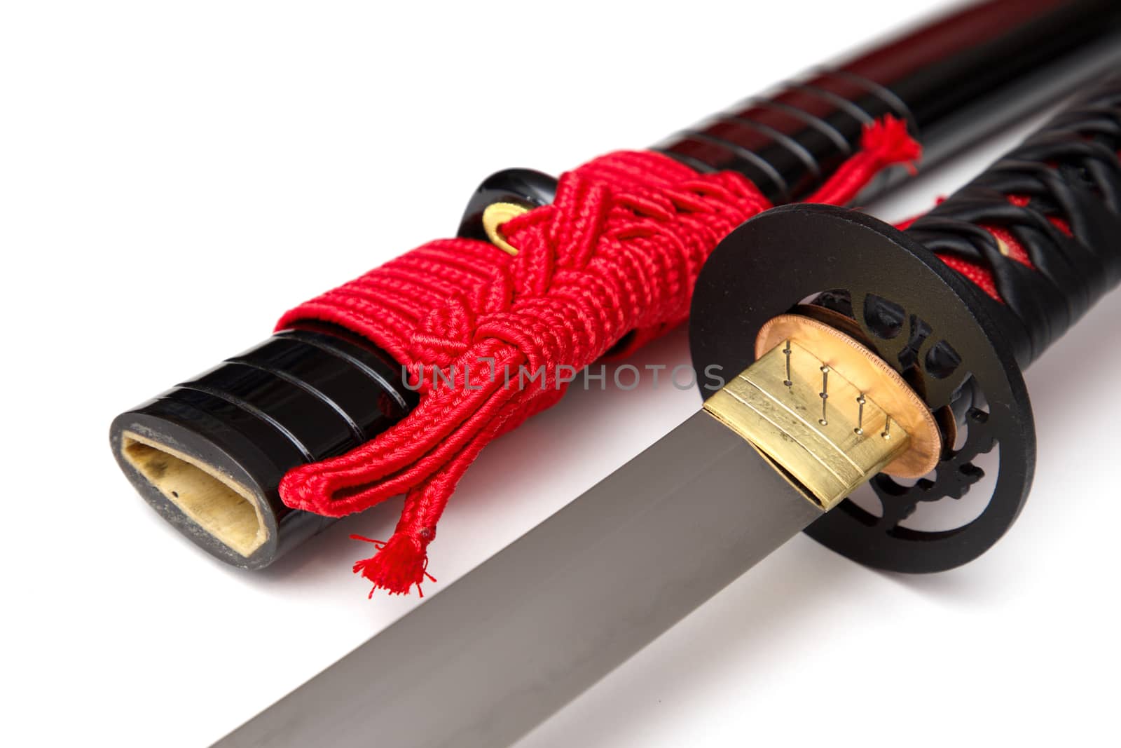 Japanese sword with red cord   steel fitting and shiny black scabbard on white background. Selective focus. by joker3753