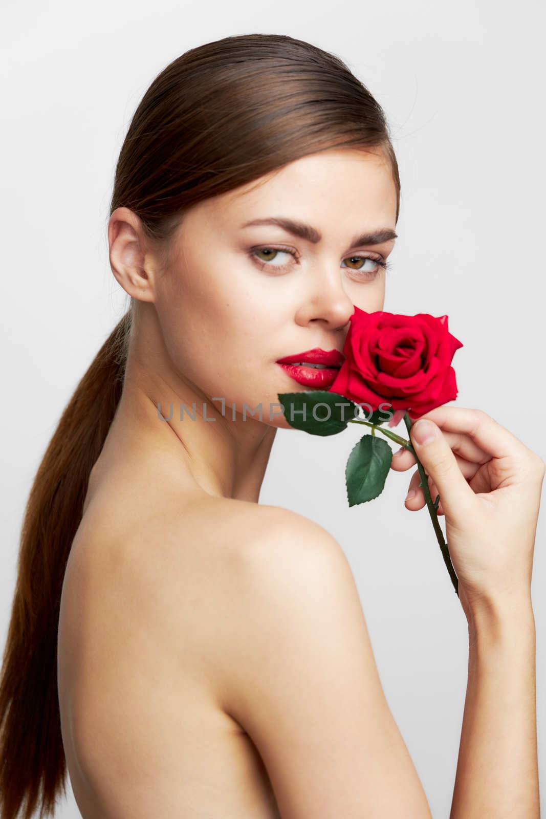 Woman with long With a rose near the face for hairstyle lipstick front view