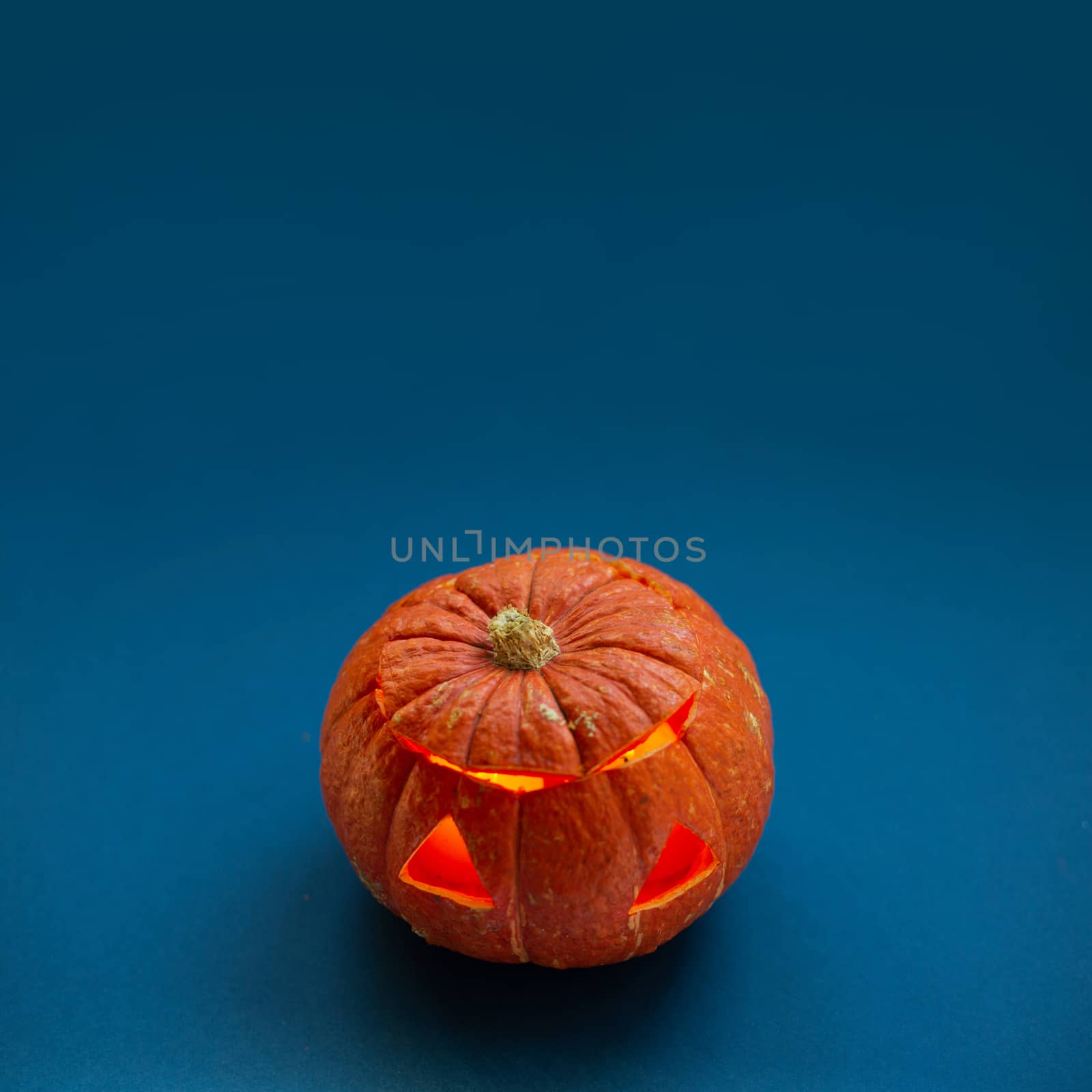 Halloween pumpkin on blue background unusual composition background with copy space for text