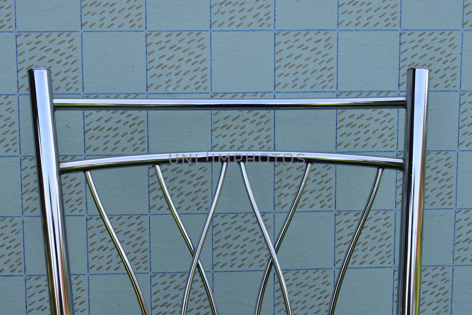 backrest of modern metal chair on vintage wallpaper background