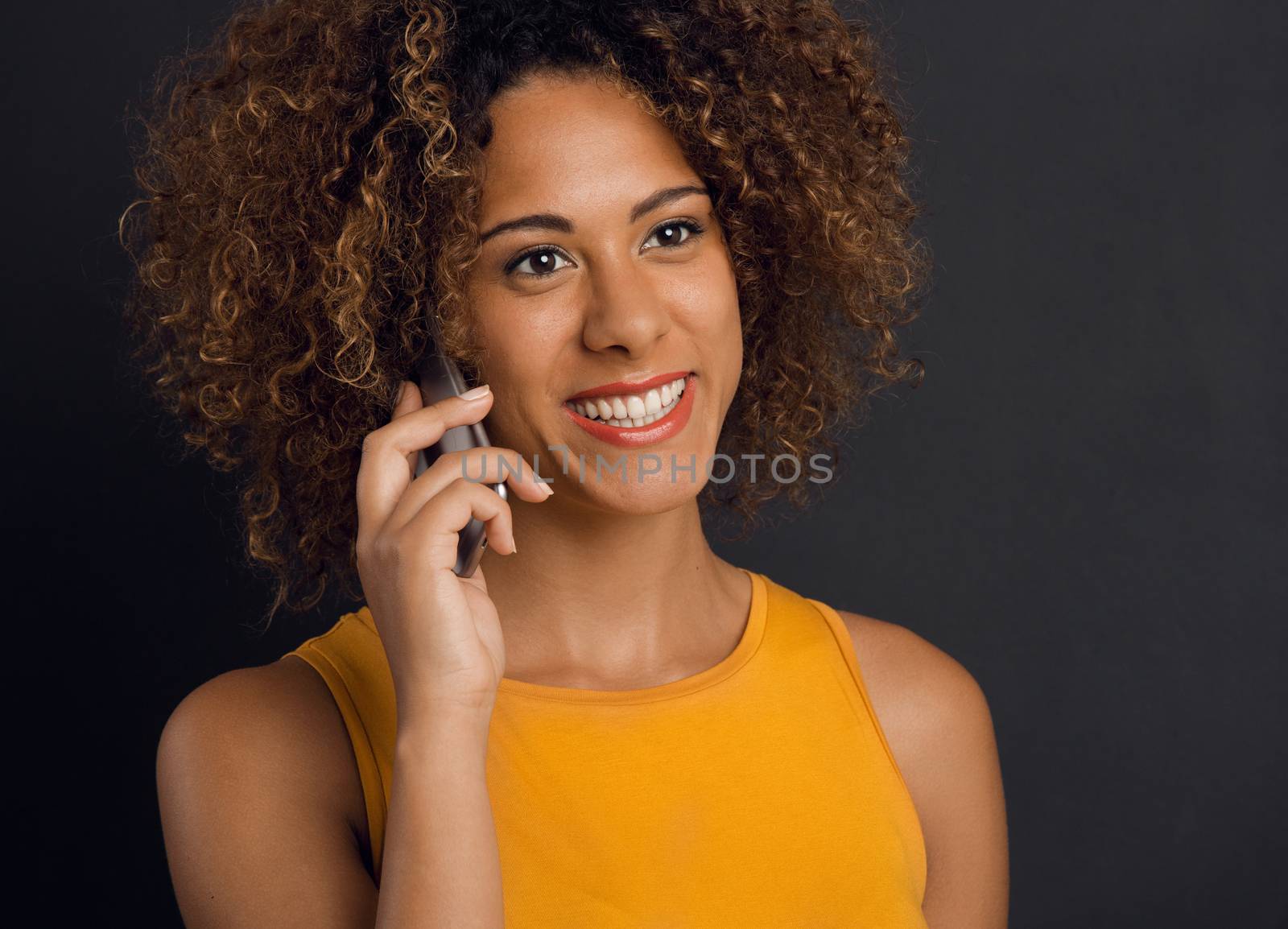 Beautiful African American woman making a phone call and laughing