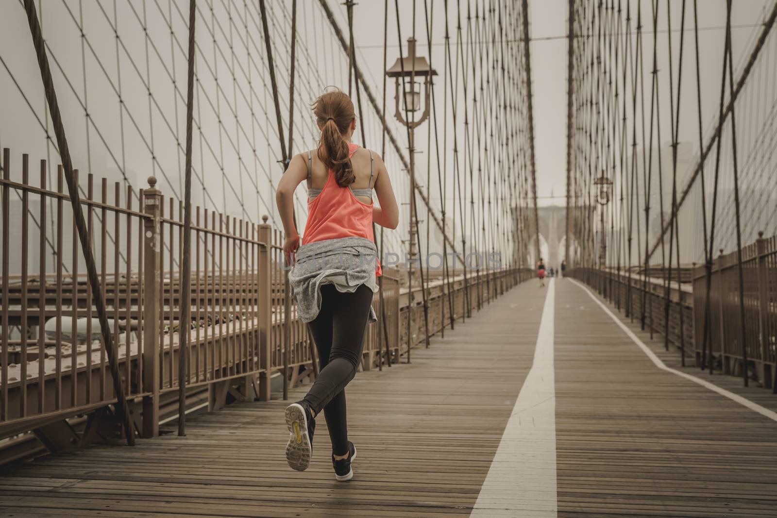 Woman practicing jogging on the Brooklyn bridge
