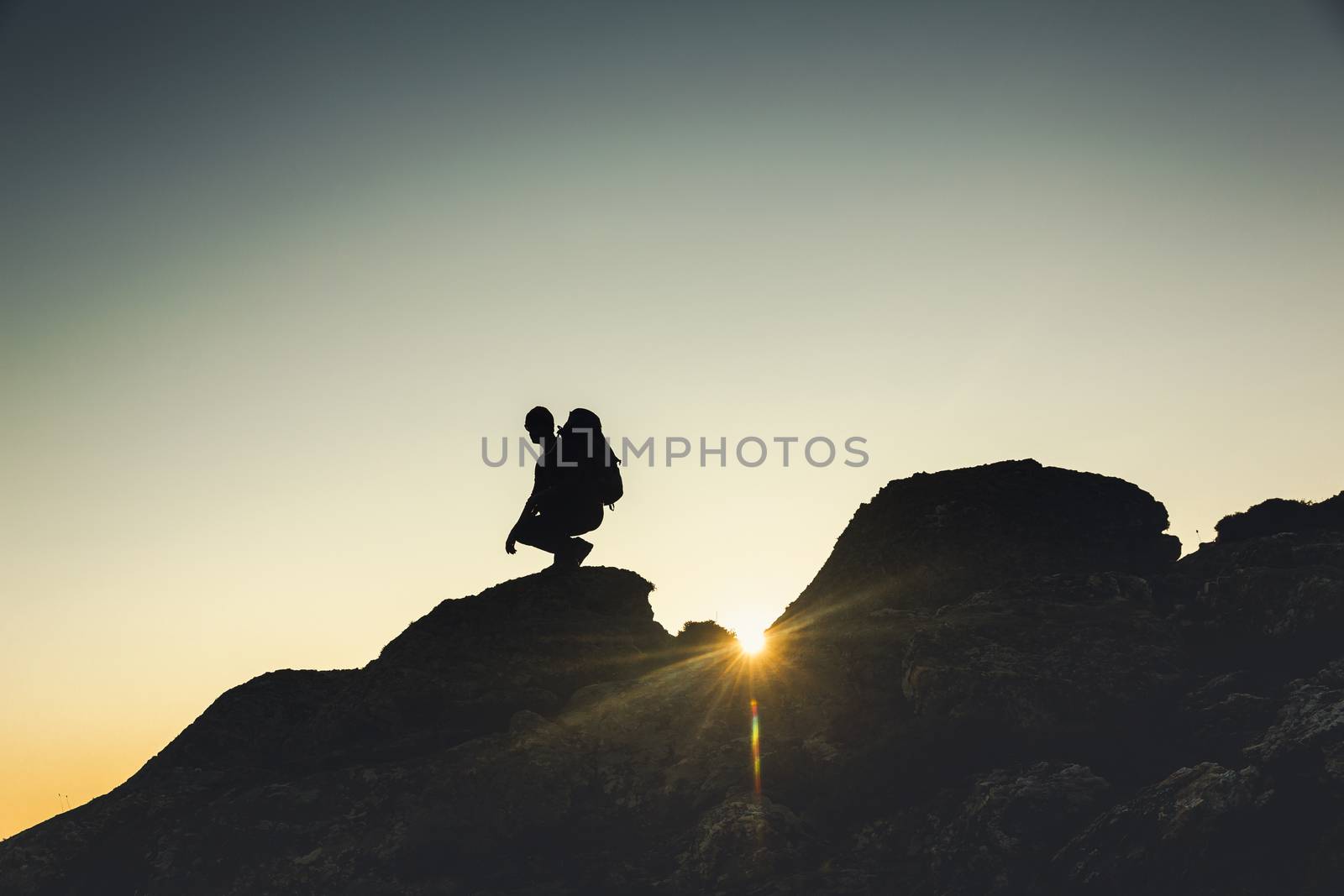 Shot of a man enjoying the view of the montains at sunset