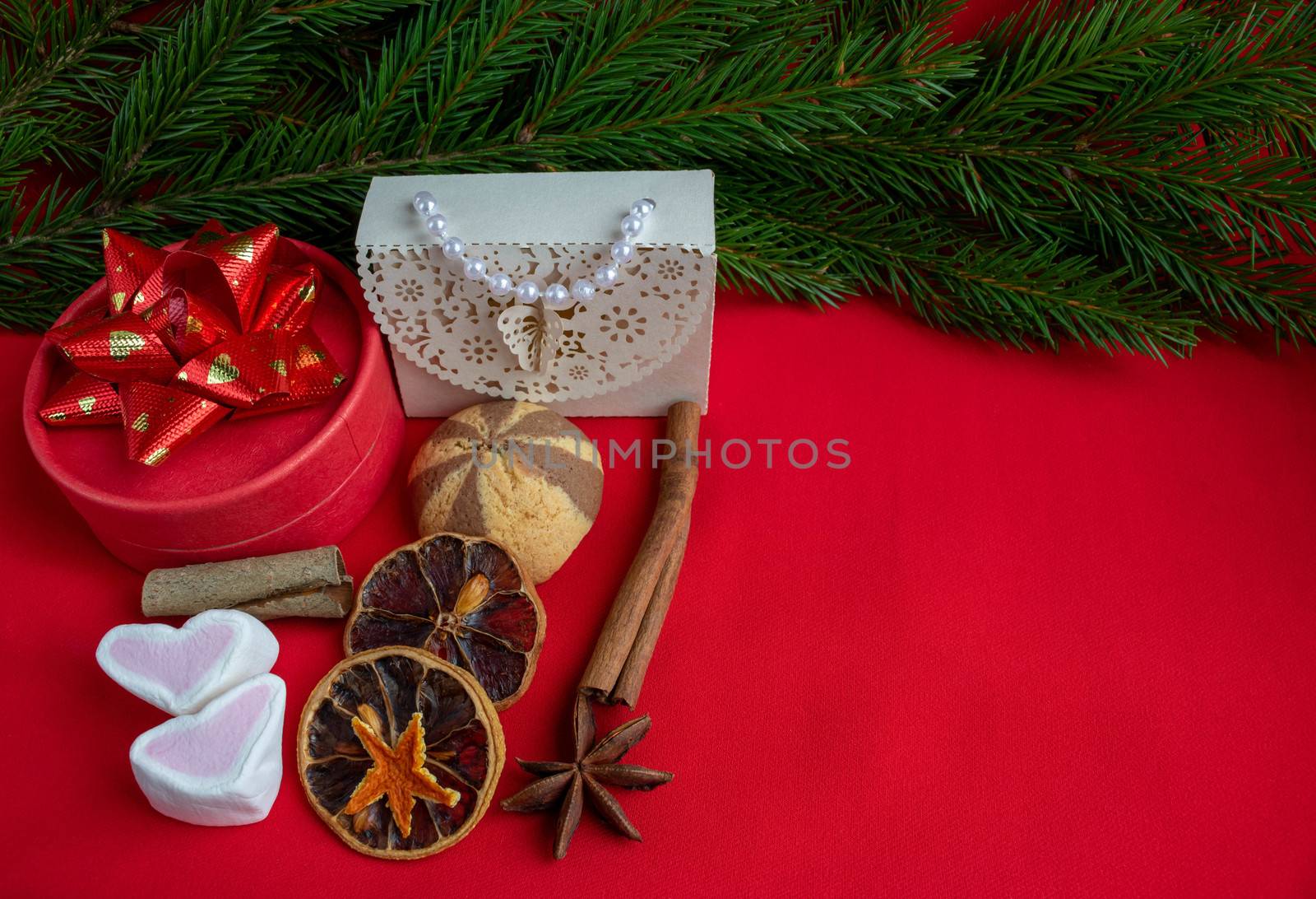 Christmas gifts lie on the background of a spruce branch on a red background. Copy of the space, banner.