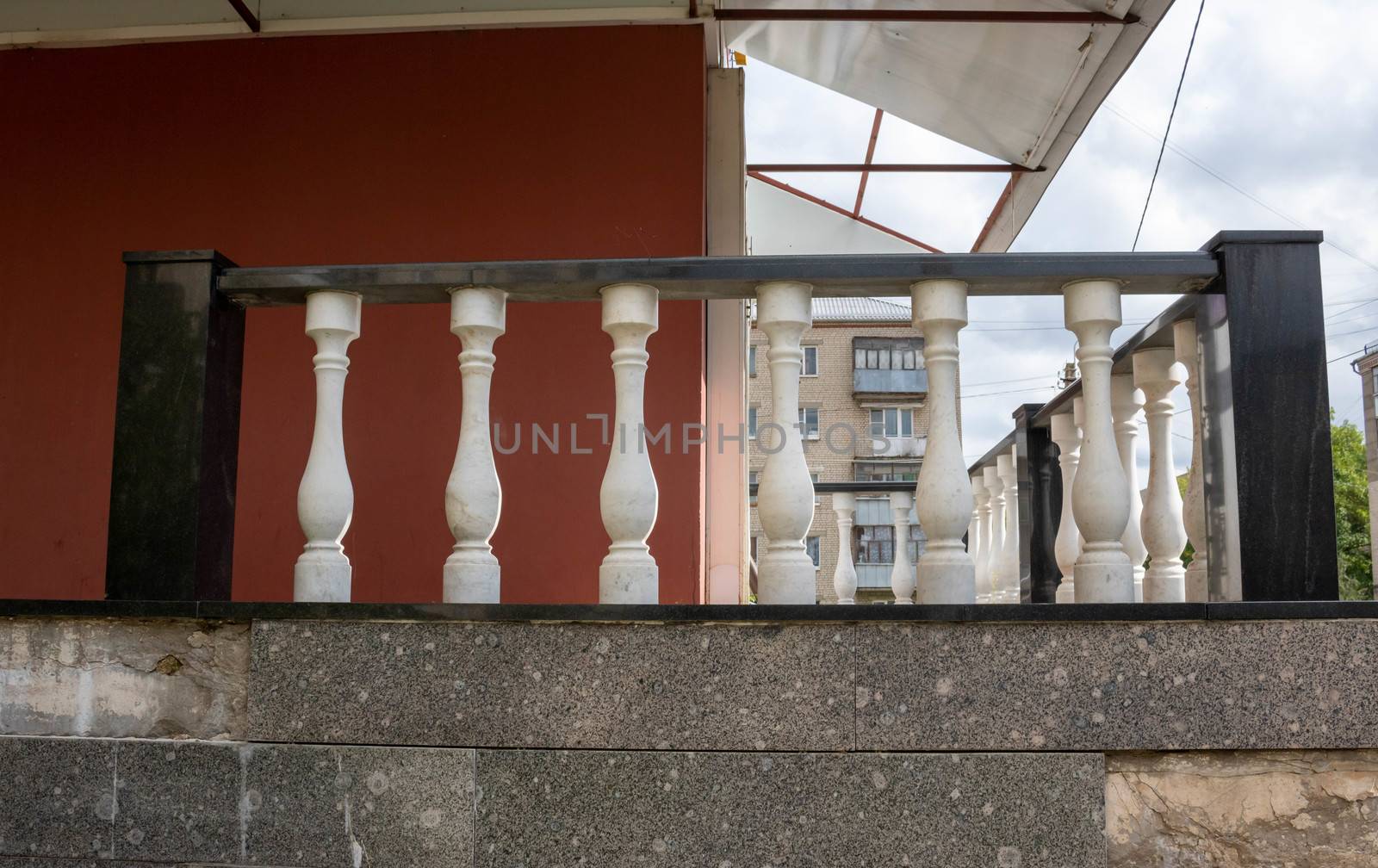 Porch with black railing and white twisted posts. The old porch.