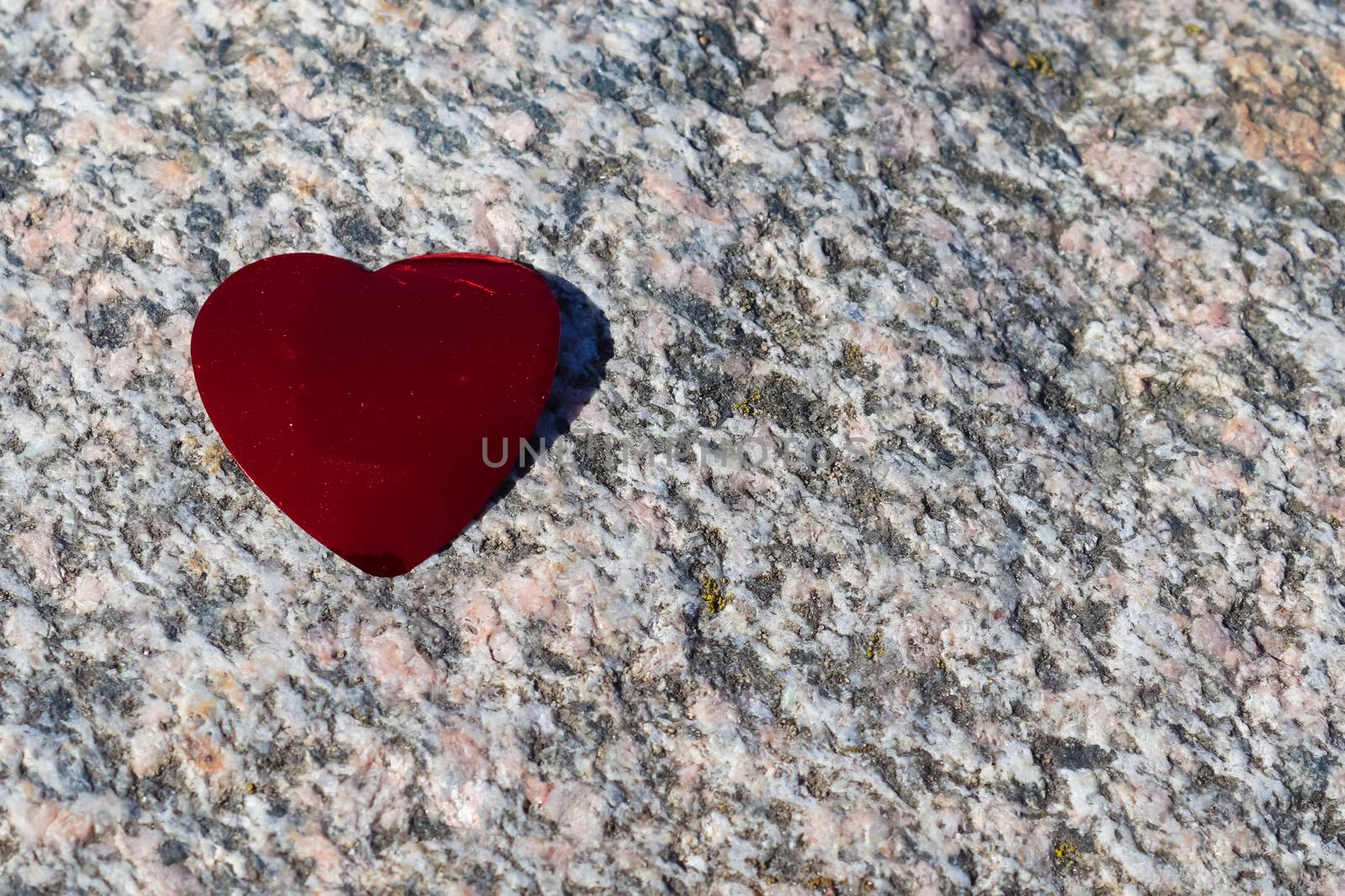 Romantic red love heart lying on a granite background