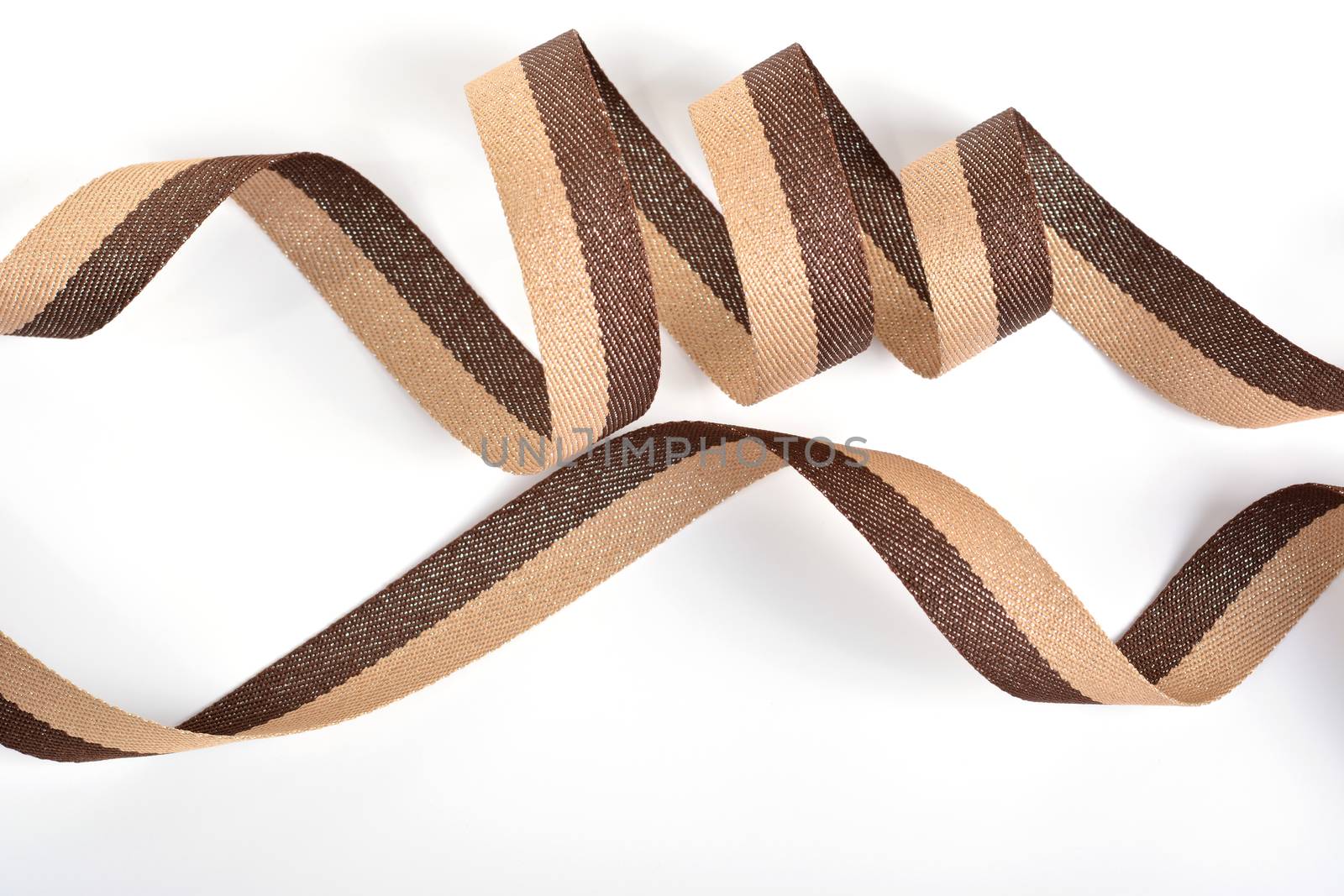 Brown beige Cotton ribbon, roll textilies on bobbin. strapping tape with curl on white backgroud. Use for sewing clothes, bags. Space for text.