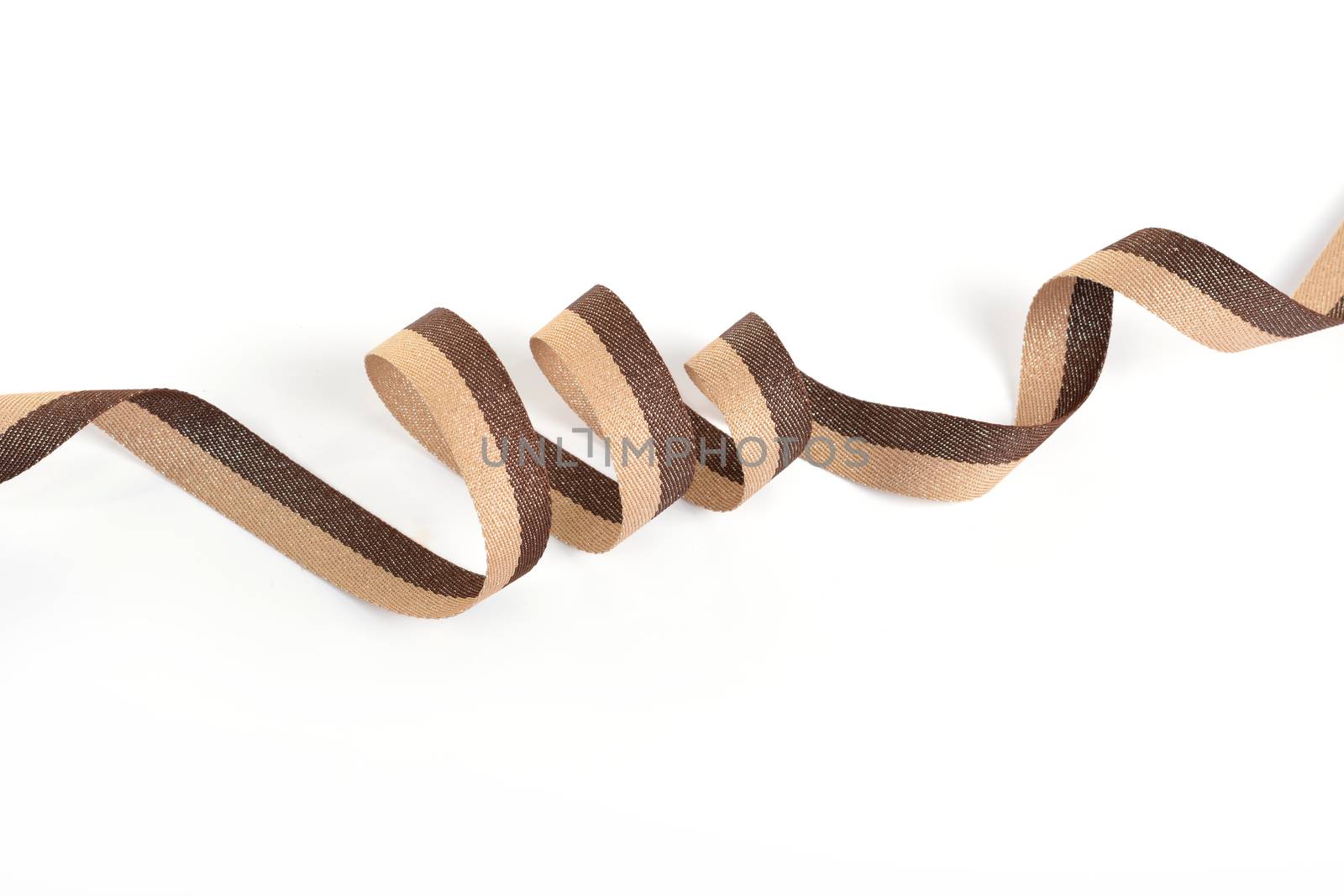 Brown beige Cotton ribbon, roll textilies on bobbin. strapping tape with curl on white backgroud. Use for sewing clothes, bags. Space for text.