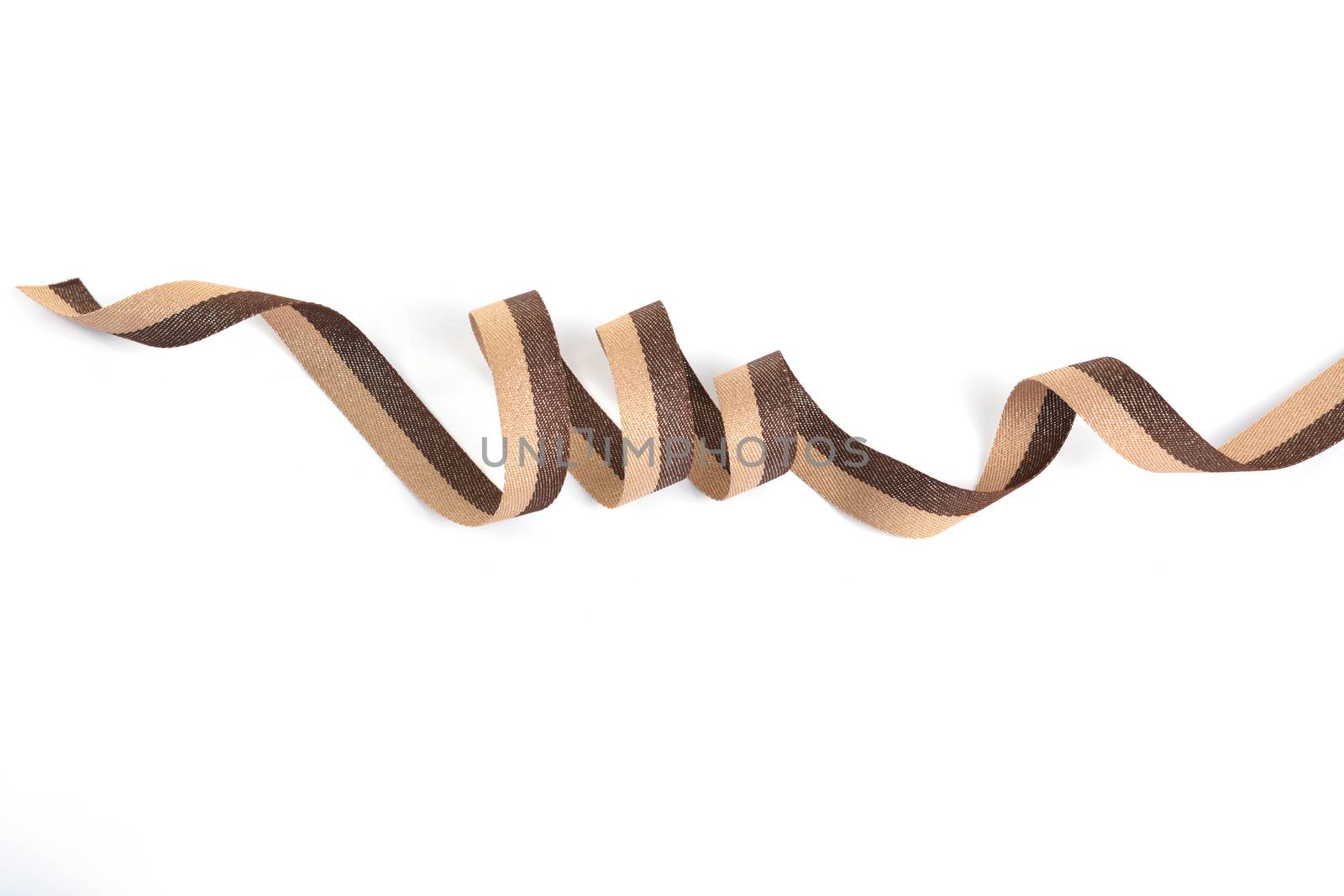 Brown beige Cotton ribbon, roll textilies on bobbin. strapping tape with curl on white backgroud. Use for sewing clothes, bags. Space for text.