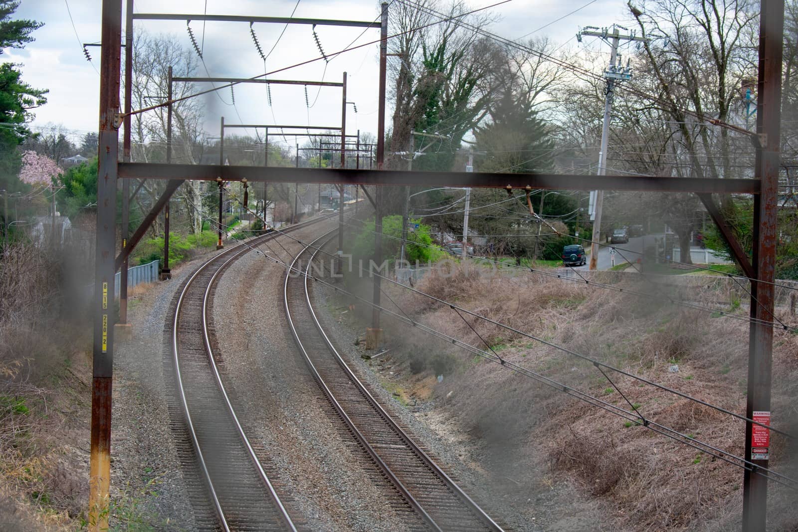 Looking Through a Metal Fence at a Railroad by bju12290