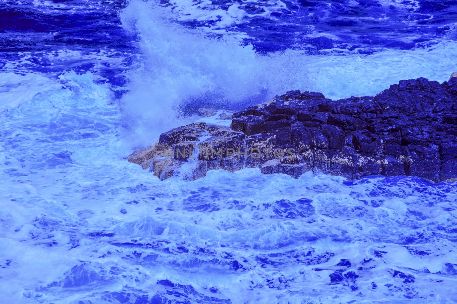 The ocean crashing on rocks with white waves in Kiama New South Wales taken in Infrared