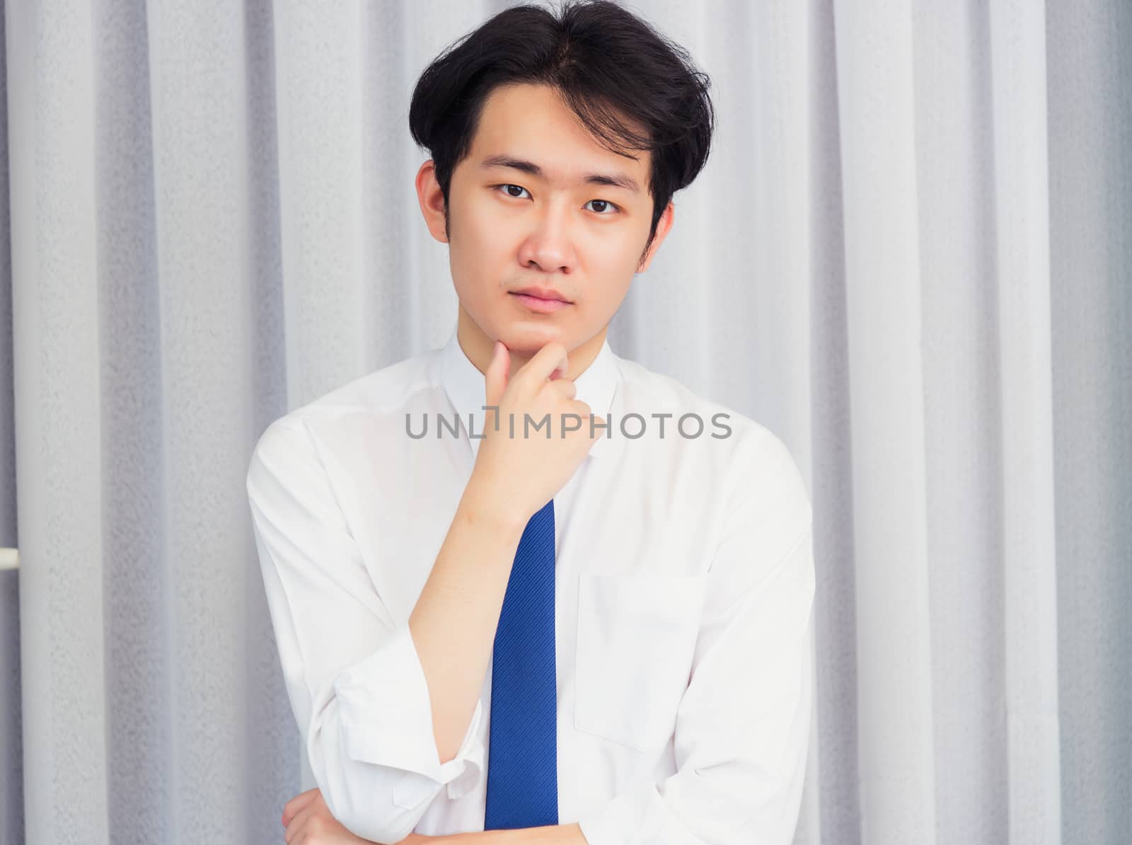 Portrait of happy business handsome man confident wearing shirt pose standing smiling looking to camera he take the hand to hold the chin