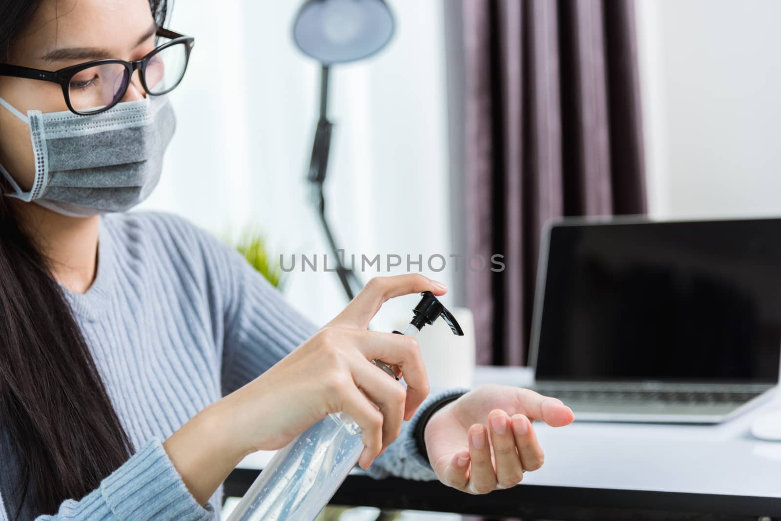 Asian young business beautiful woman wearing face mask protective working from home office with laptop computer desk he quarantines disease coronavirus and cleaning hands by sanitizer alcohol gel pump