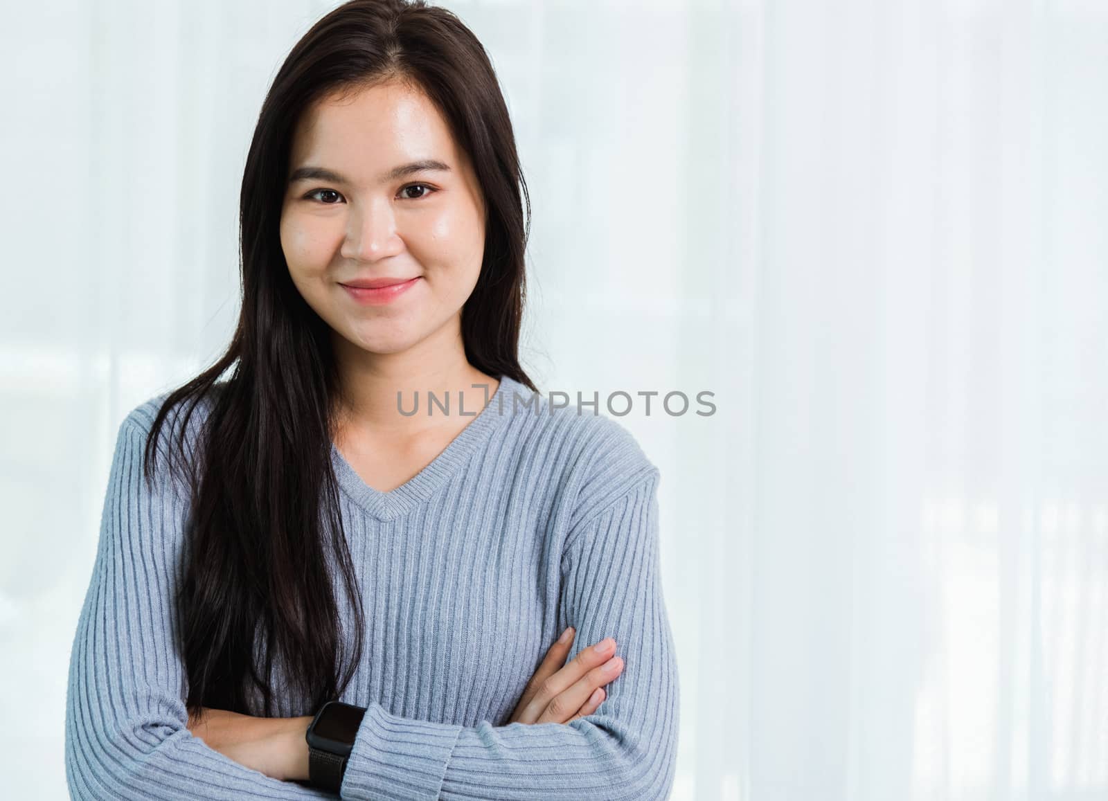 Close up headshot portrait young Asian happy beautiful woman healthy smiling face long hair stand crossed arm, studio shot looking to camera at home and have a copy space