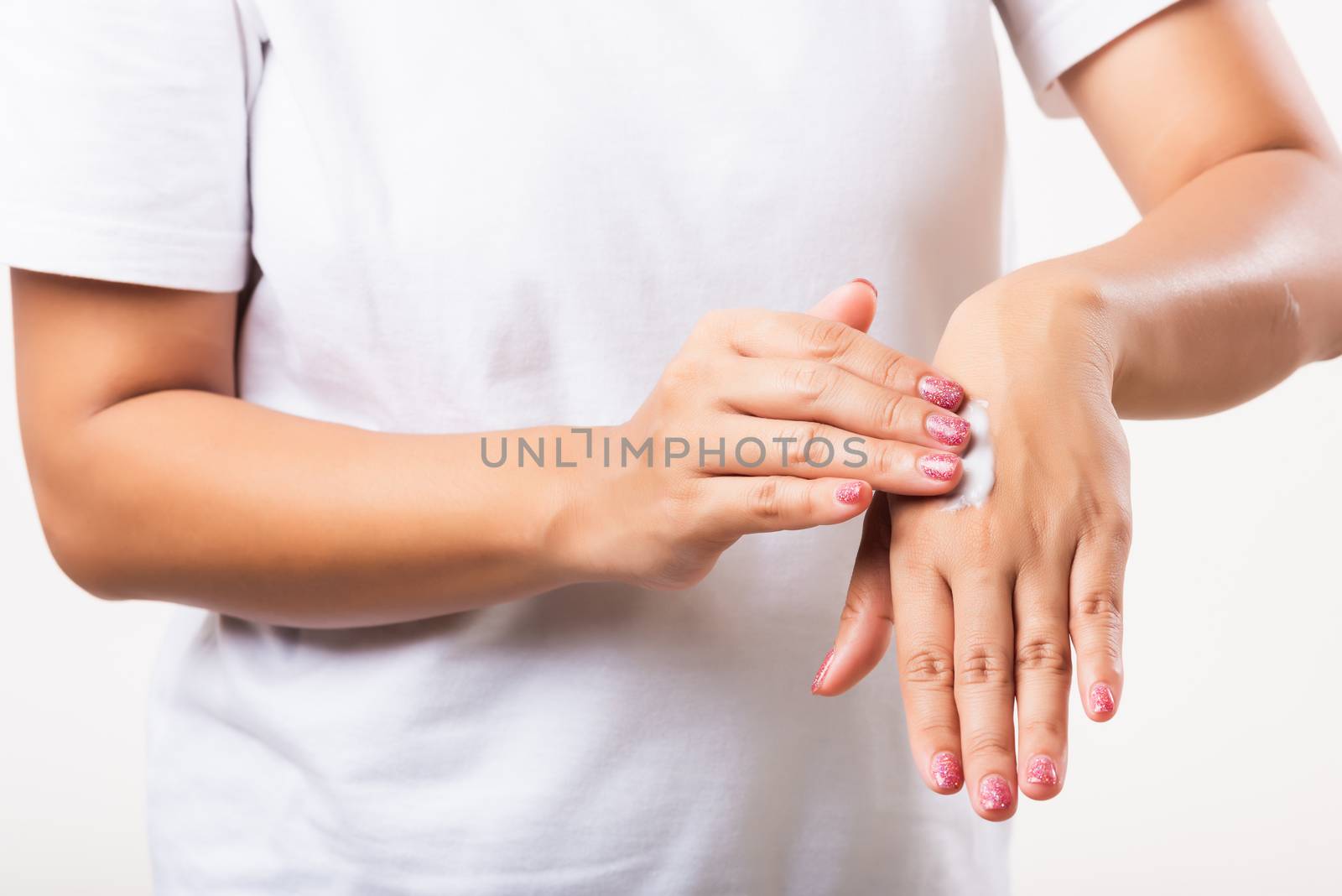 Closeup young Asian woman applying lotion cosmetic moisturizer cream on her behind the palm skin hand, studio shot isolated on white background, Healthcare medical and hygiene skin body care concept