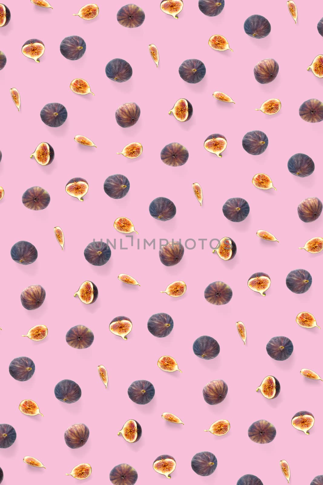 Background from Fresh figs. Food Photo. Modern fig fruits background. Creative set of the whole and sliced figs on a pink background, not pattern