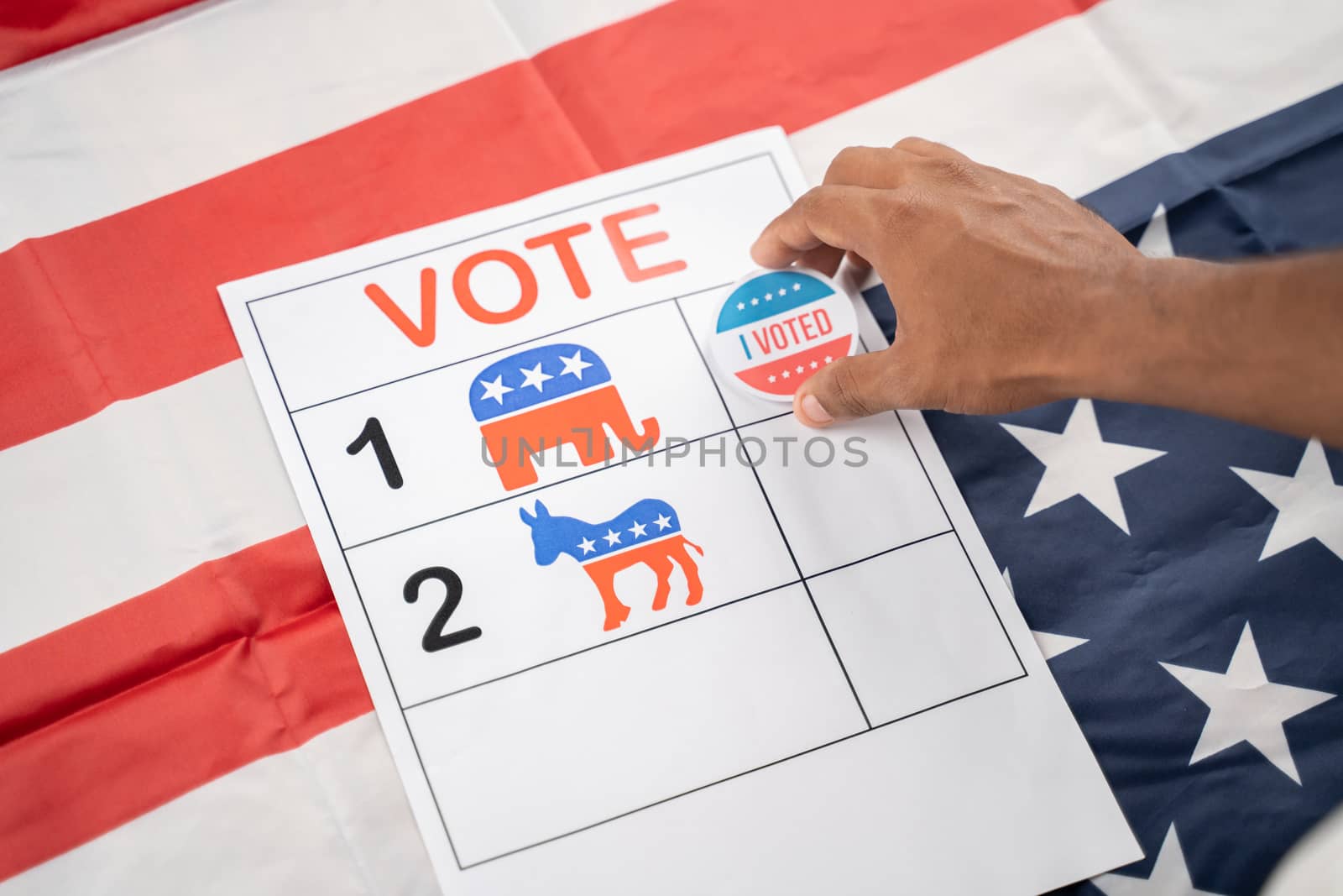 Hands placing I voted Sticker on republican party symbol - concept of voting to republicans at US election by lakshmiprasad.maski@gmai.com