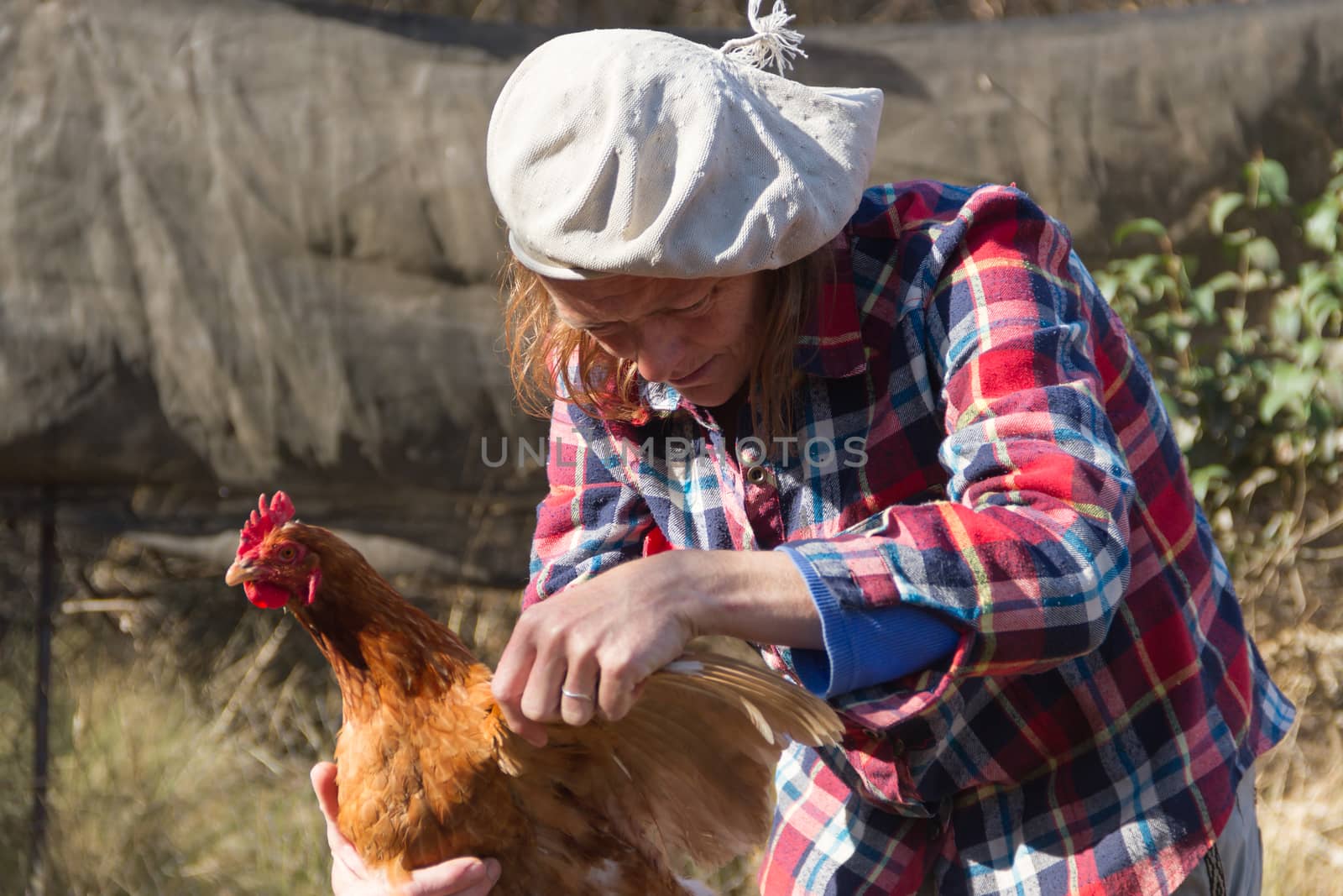 portrait of an Argentine farm worker woman with a hen