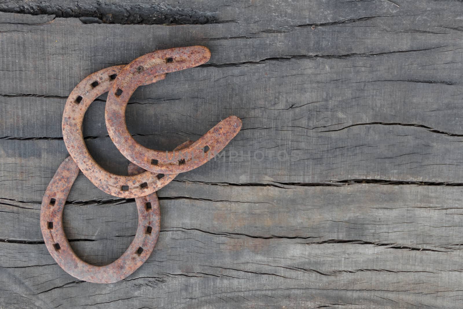 old rusty horseshoes on rustic wood with place for text by GabrielaBertolini